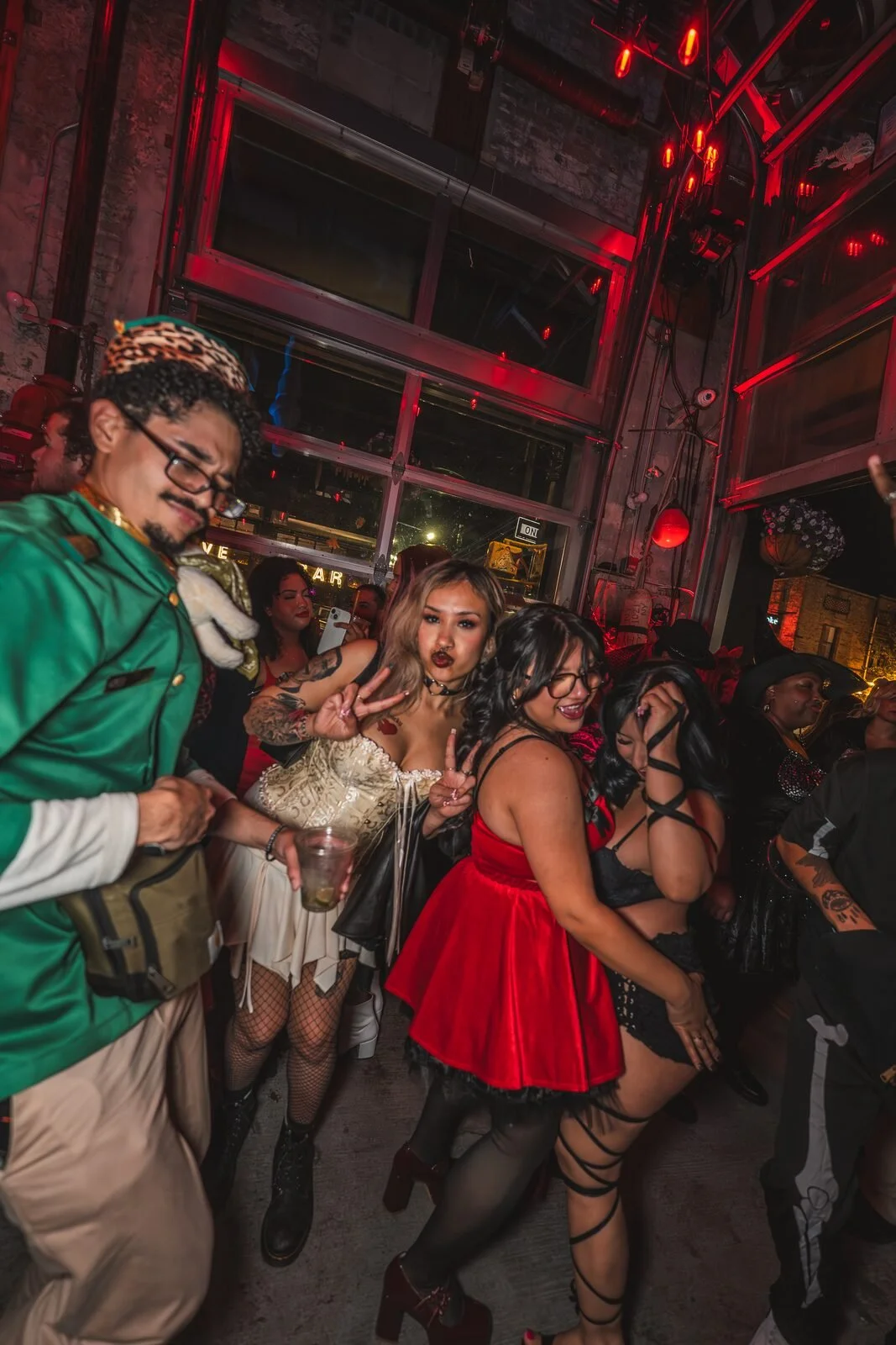 Friends in Halloween costumes, including a red dress and a green tunic, dancing at Sea Wolf in Bushwick, Brooklyn