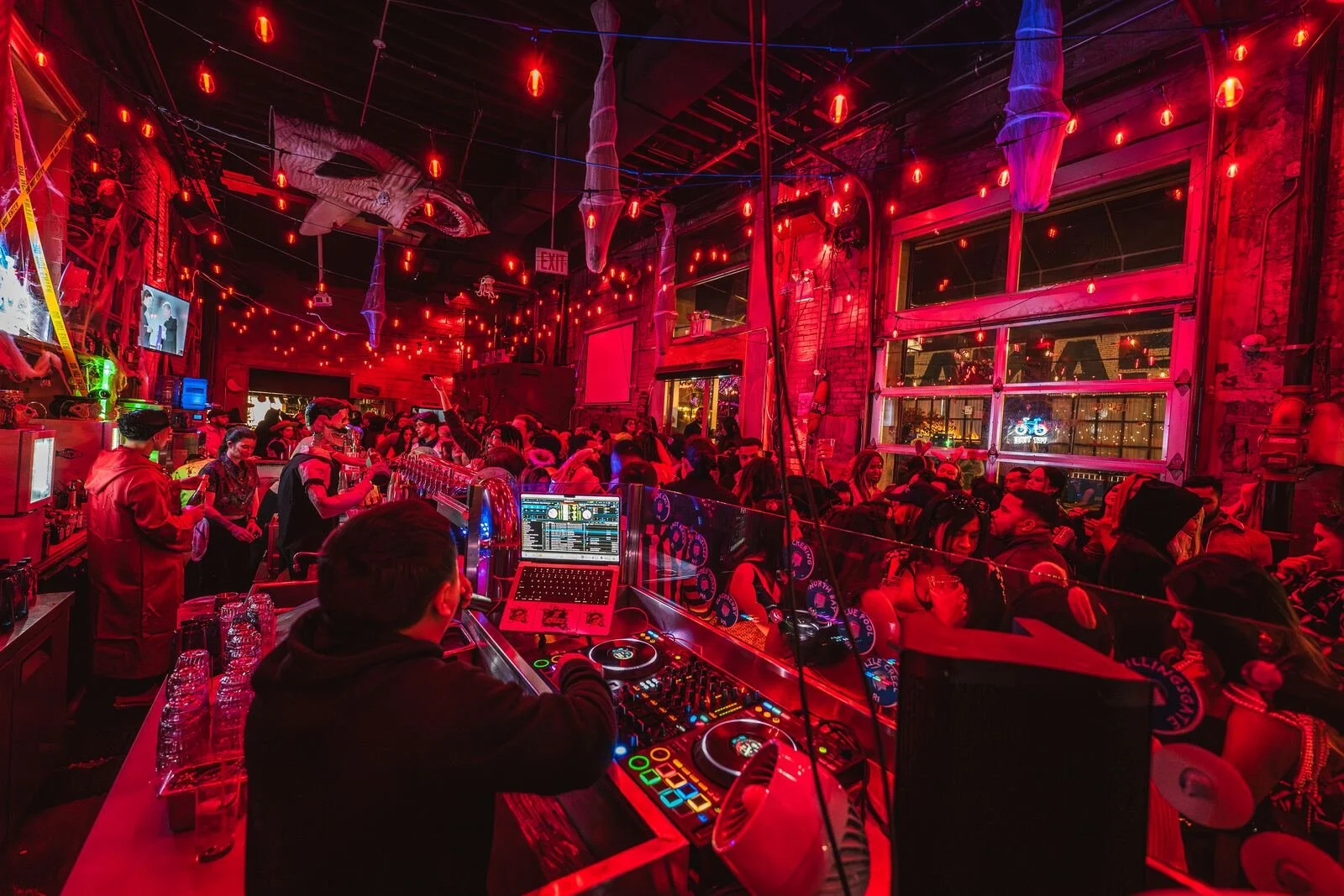 View from the DJ decks over a packed, red-lit dance floor at Sea Wolf in Bushwick, Brooklyn