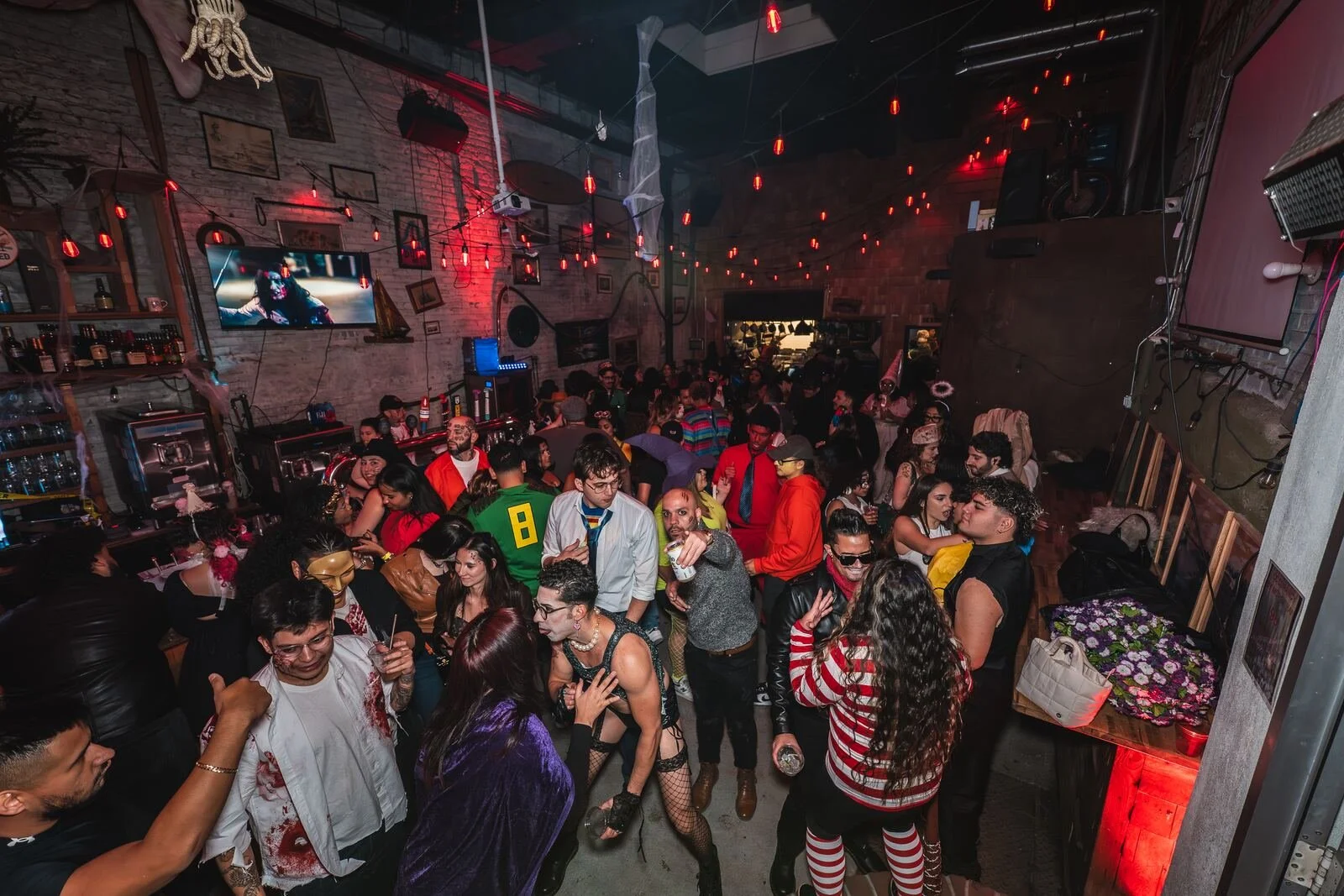 Guests in Halloween costumes dancing in the bar room at Sea Wolf in Bushwick, Brooklyn