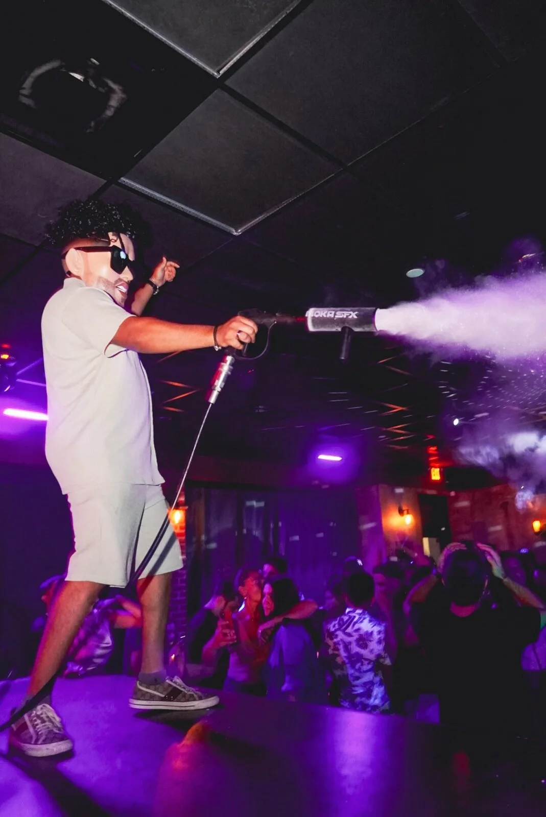 Throwback: performer in sunglasses firing a CO2 cannon from the stage at Republic in Williamsburg, Brooklyn