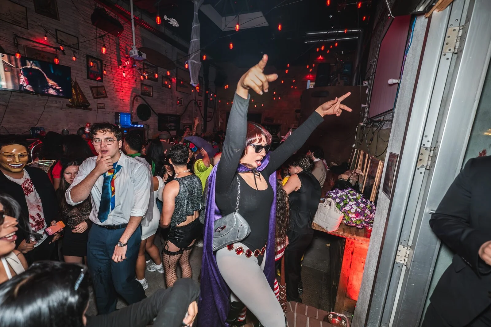 Guest in a purple cape pointing both hands up on the dance floor at Sea Wolf in Bushwick, Brooklyn