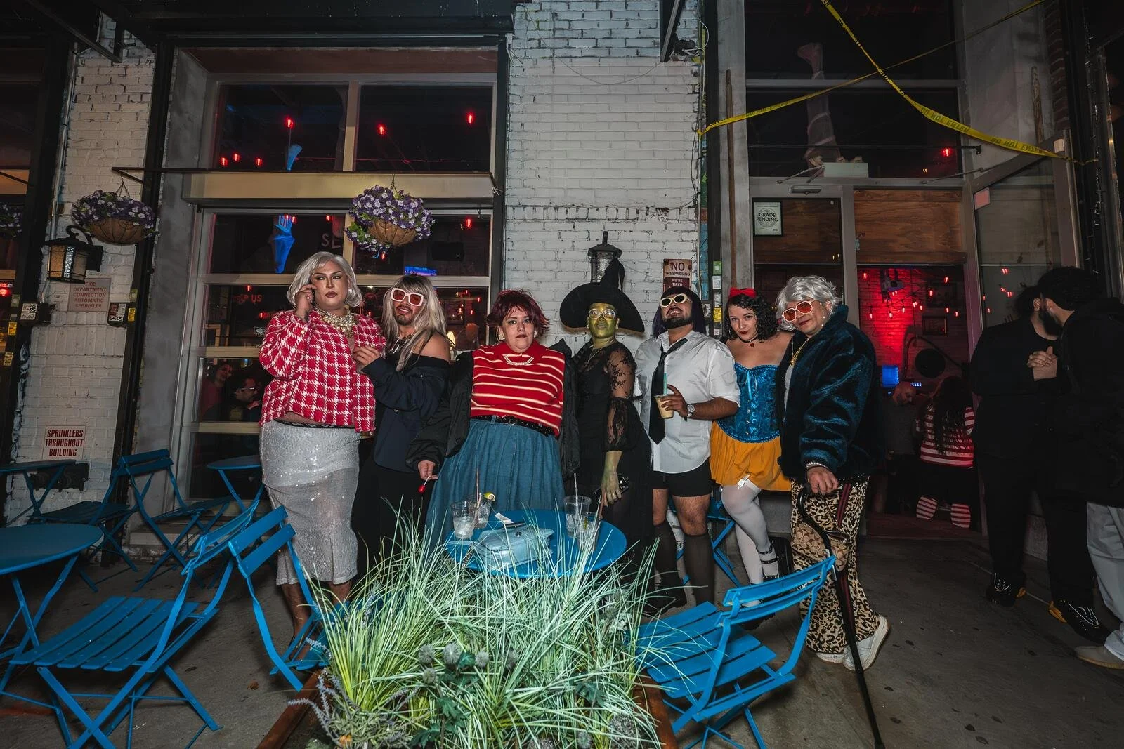 Costumed guests hanging out on the patio with blue chairs at Sea Wolf in Bushwick, Brooklyn