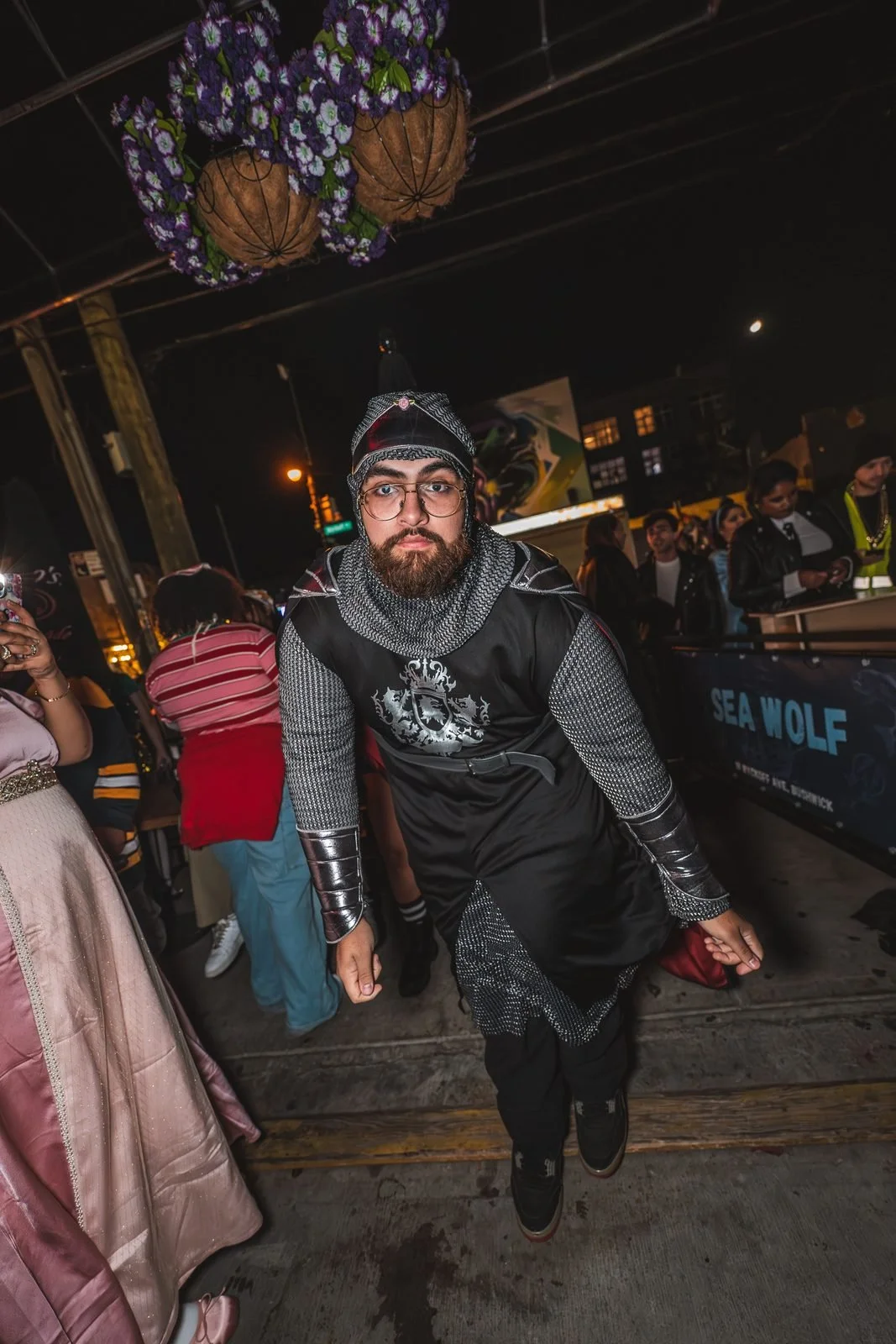 Guest in a knight costume with a chainmail hood outside Sea Wolf at Monstera Nightlife in Bushwick, Brooklyn, Halloween 2025