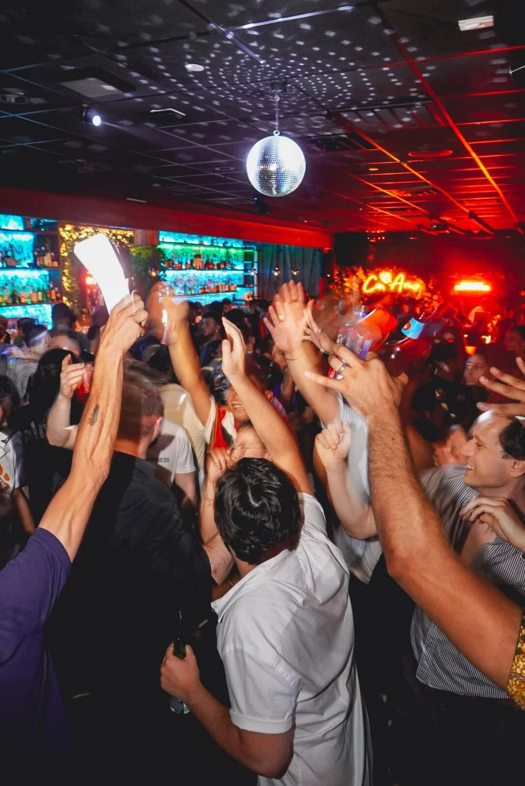 Throwback: crowd with hands raised under a disco ball at Republic in Williamsburg, Brooklyn