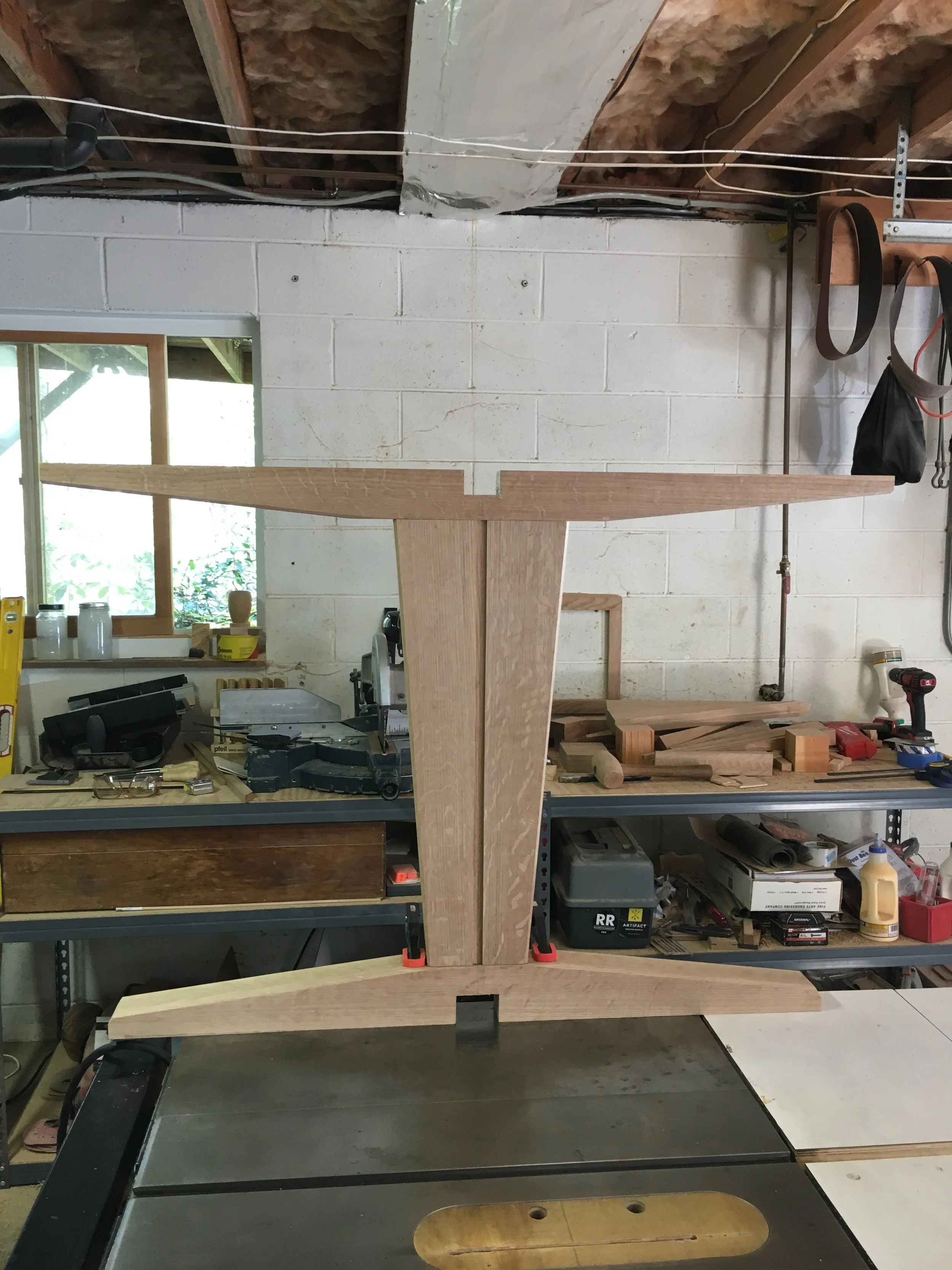 Custom solid wood table base with exposed joinery in workshop setting