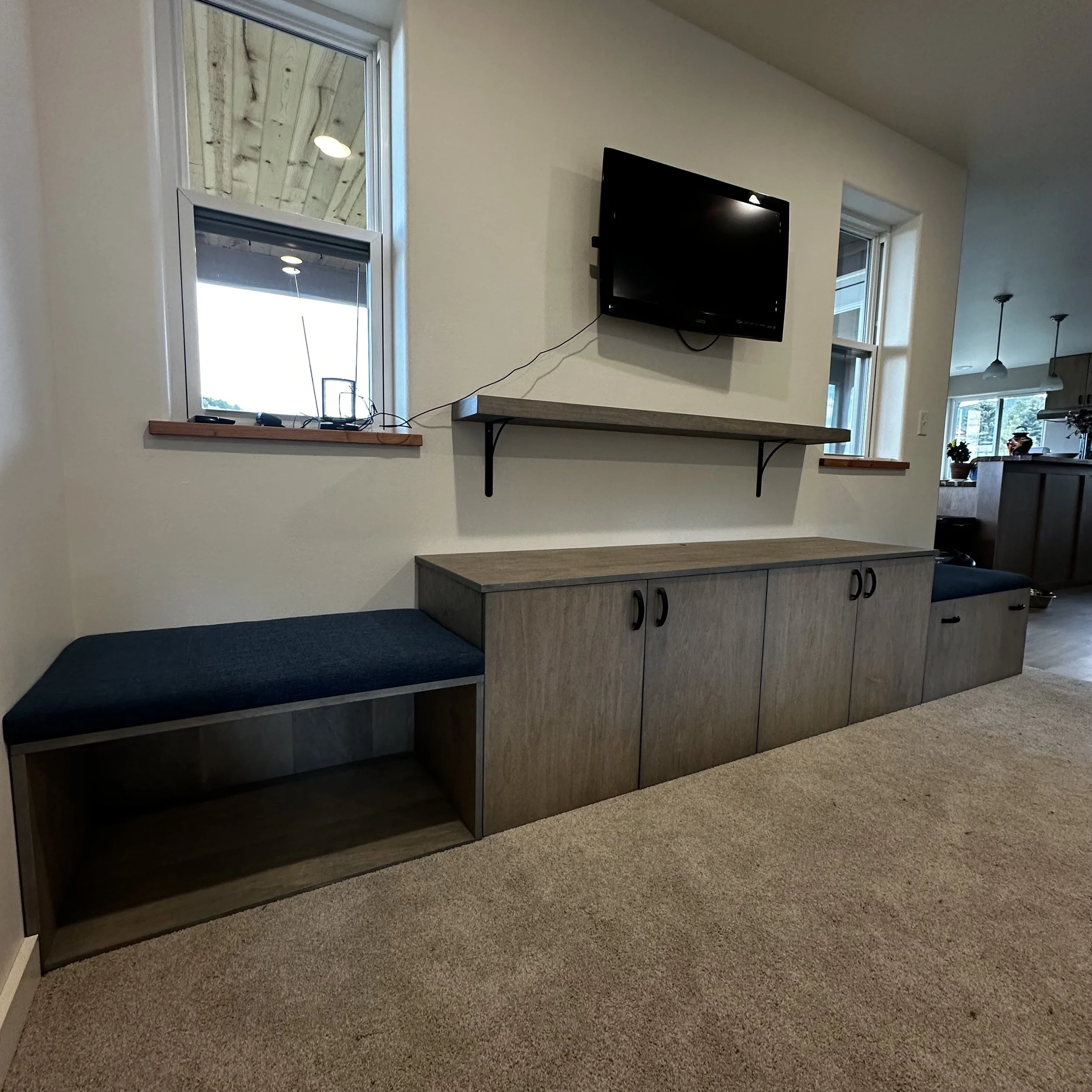 Custom entertainment unit with storage benches and wall-mounted shelving