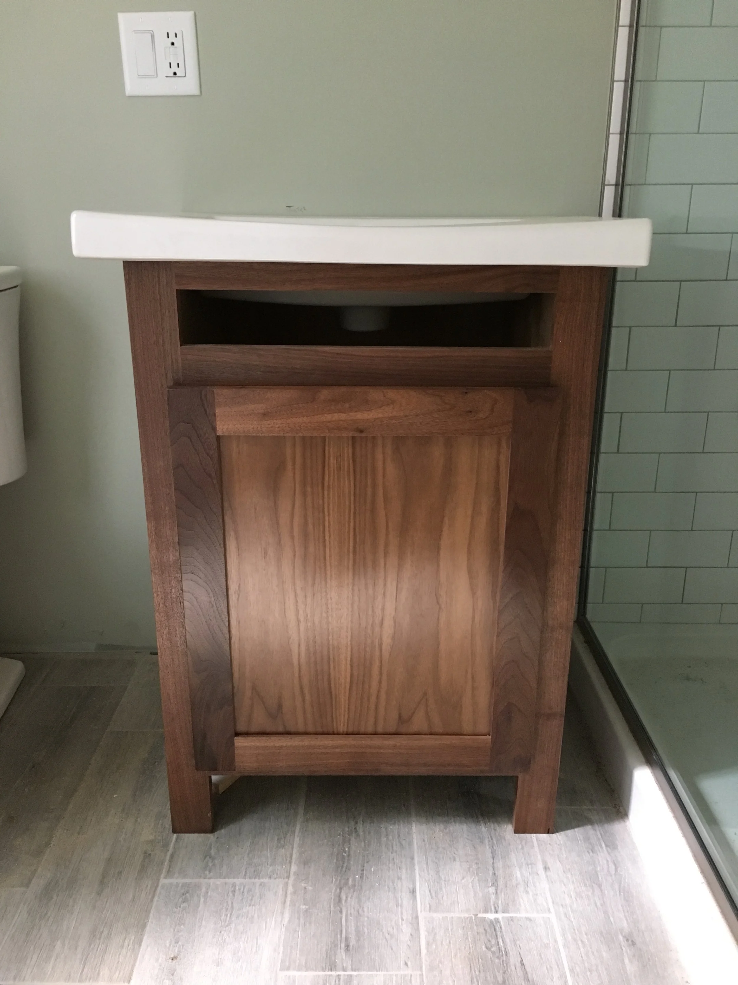 Custom walnut bathroom vanity with integrated storage and natural finish