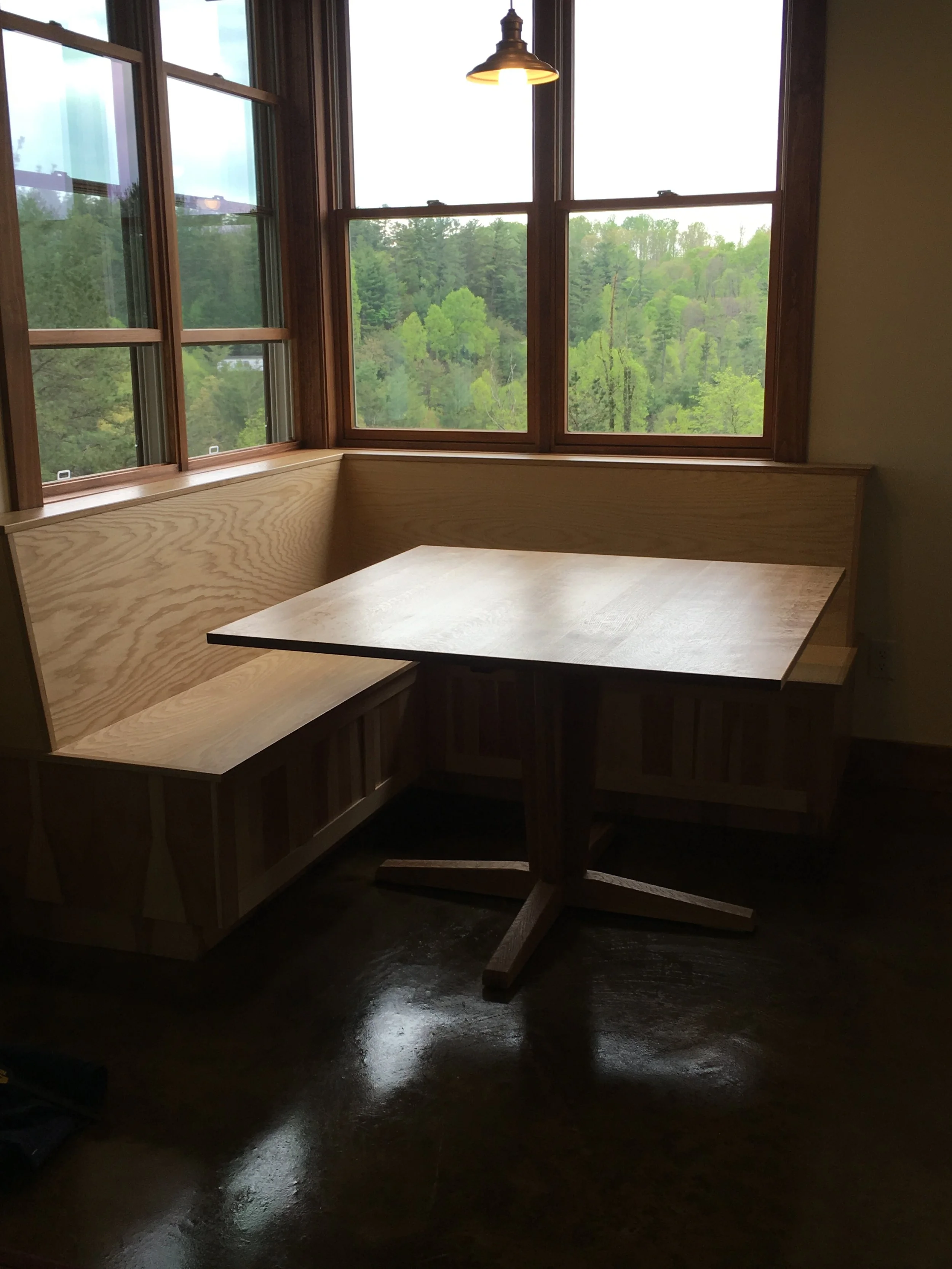Built-in wood bench seating with custom table in dining nook