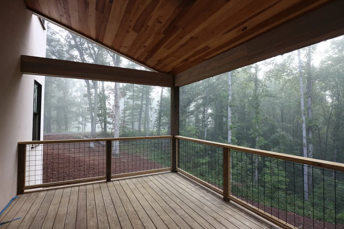 Pressure-treated wood deck with custom railing and forest views