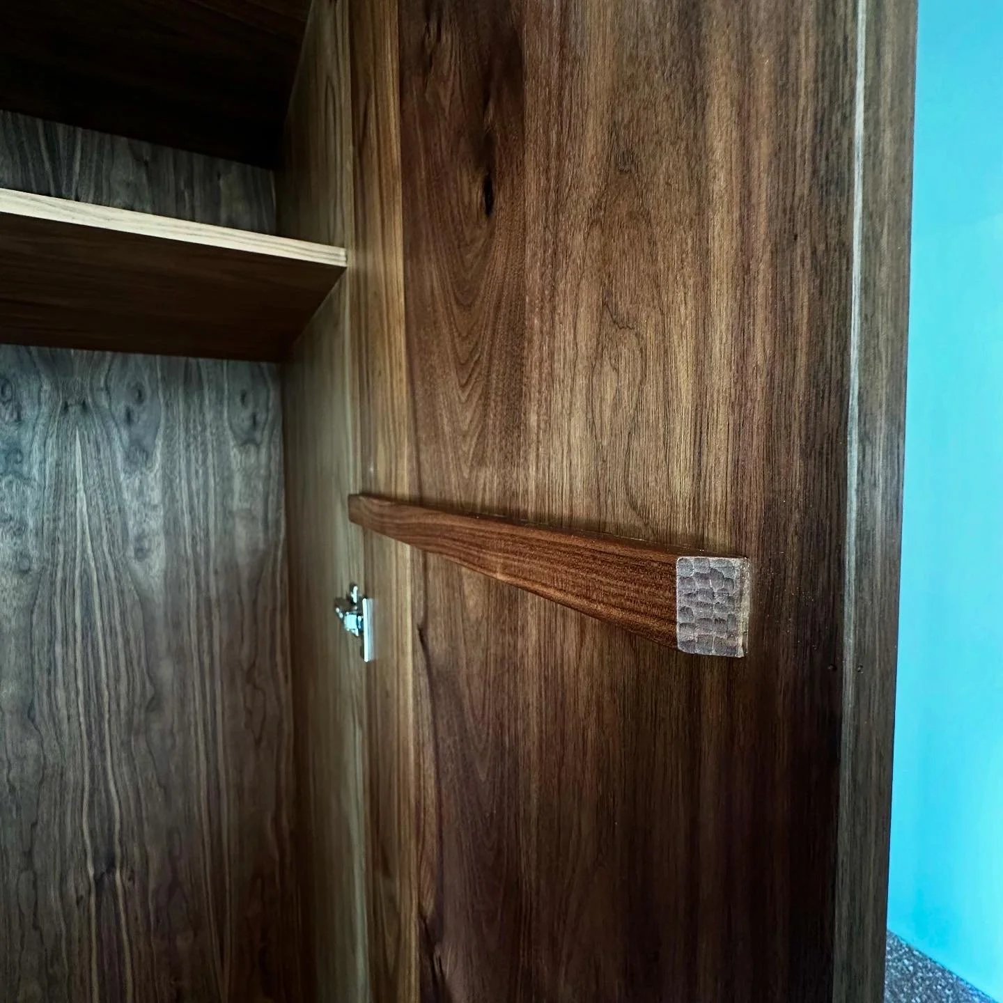 Hand-carved wooden wardrobe handle detail in walnut