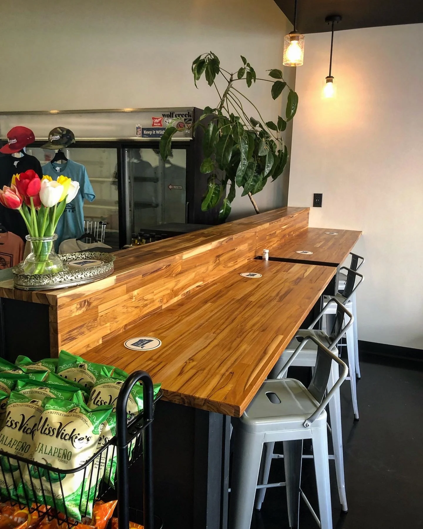 Wood bar counter with natural finish and seating area in restaurant interior