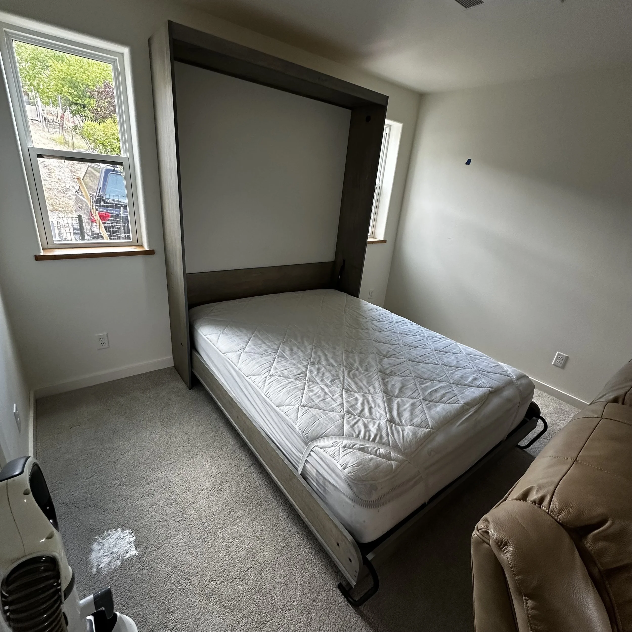 Fold-down murphy bed with integrated cabinetry in small space