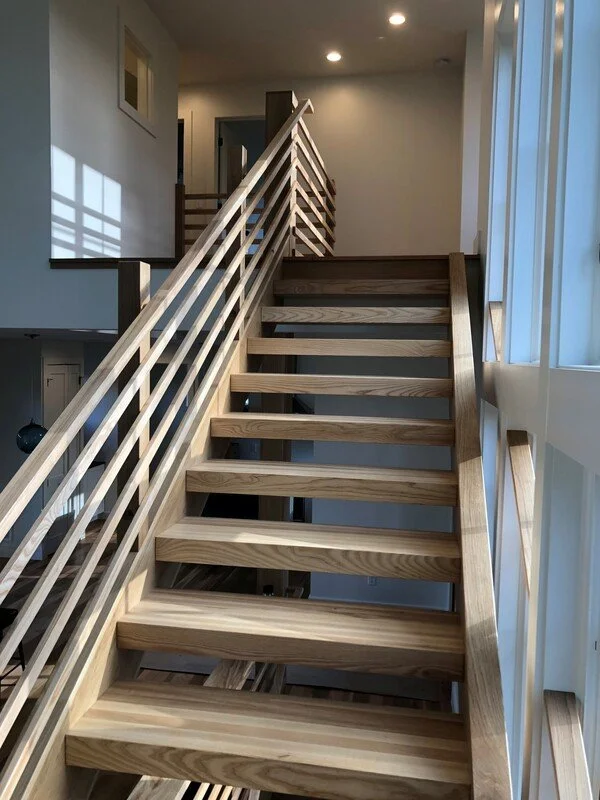 Custom interior staircase with wood railing and open riser design