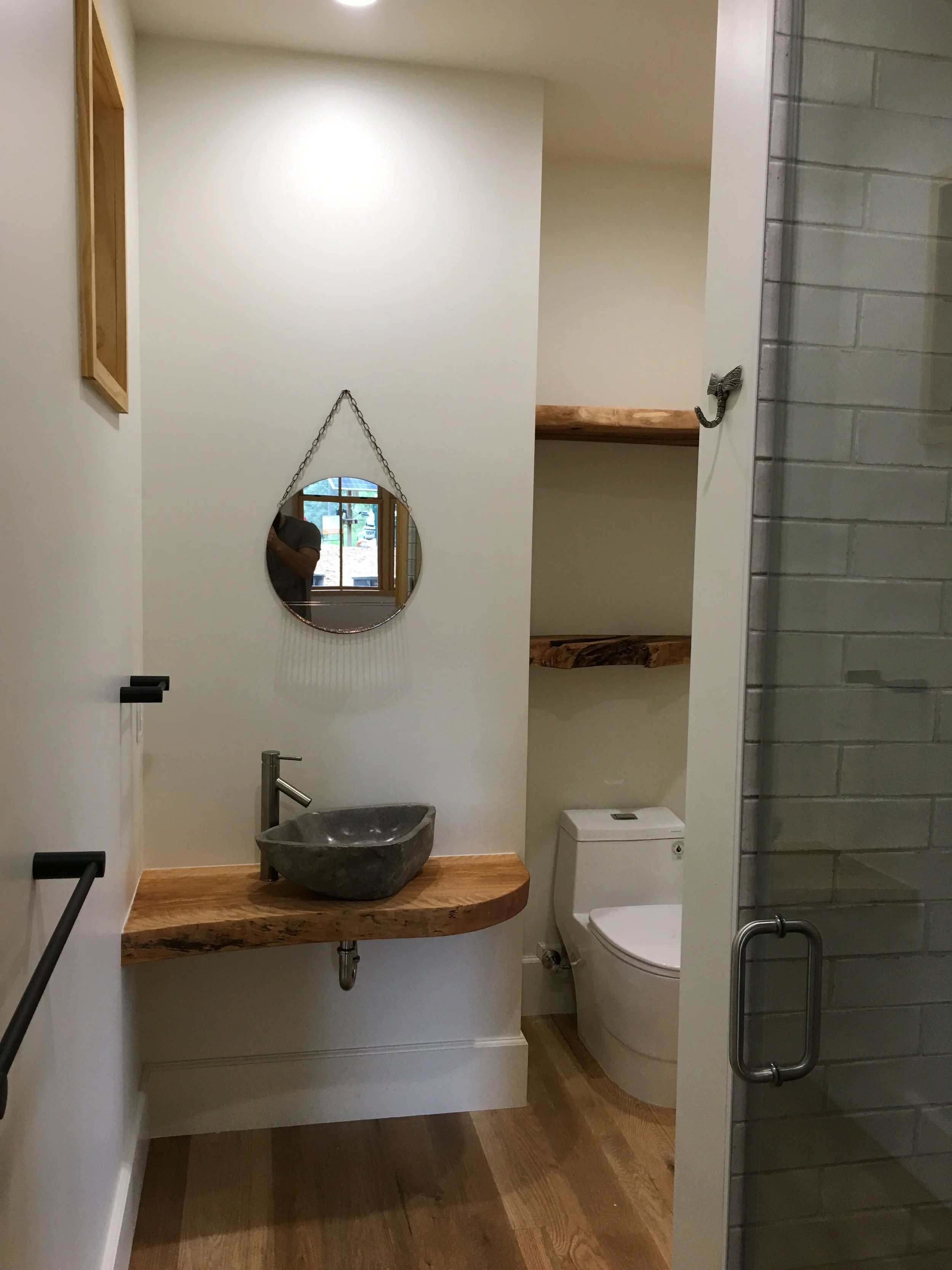 Custom powder room with spalted maple floating shelf, wood countertop, and stone vessel sink