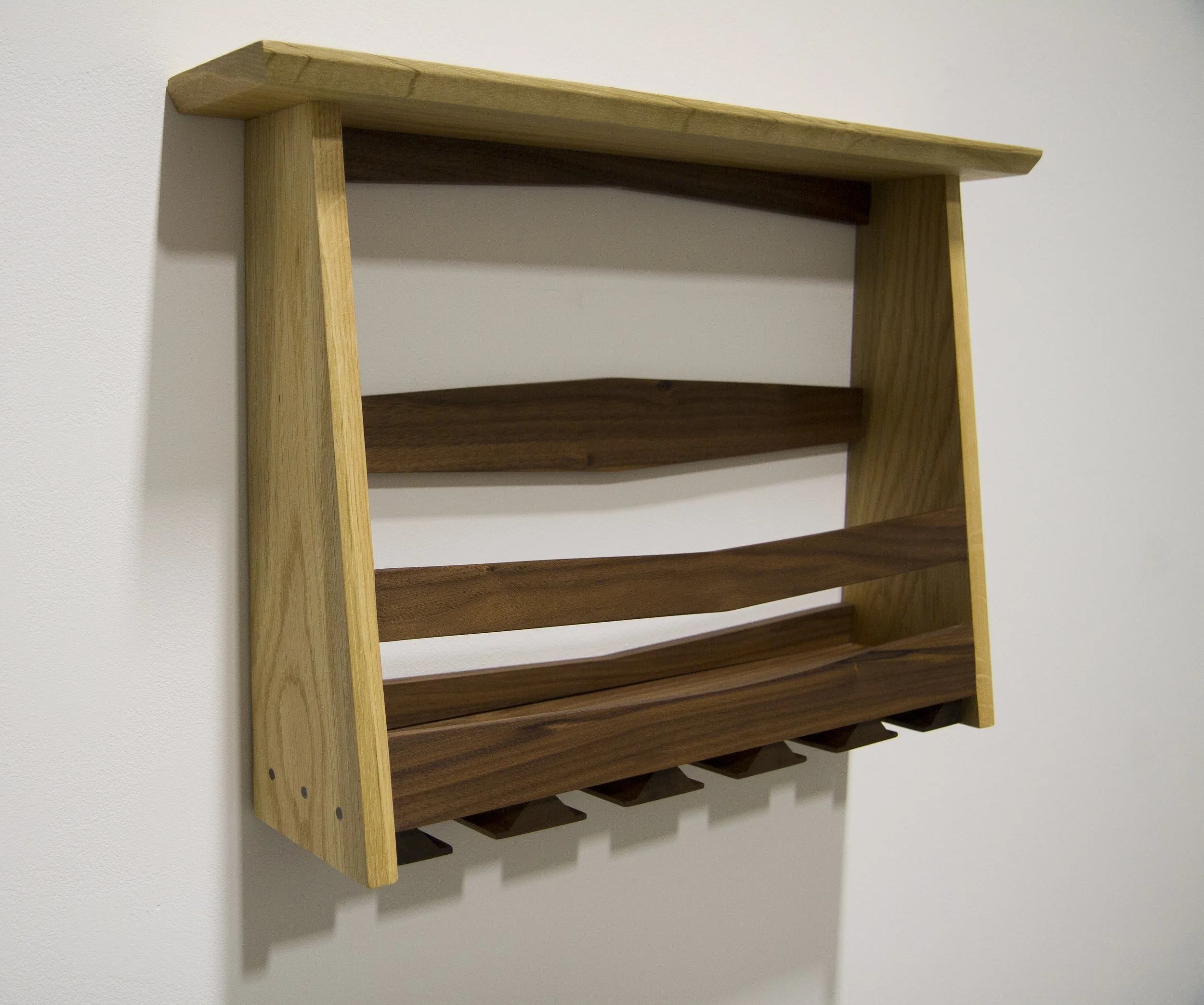 Wall-mounted wine rack in white oak and walnut with integrated bottle storage