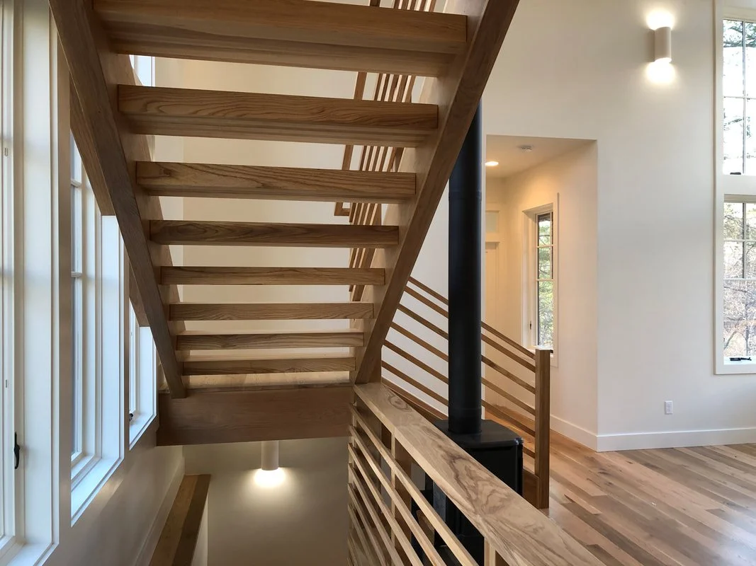 Custom floating staircase with solid ash treads and white oak railing