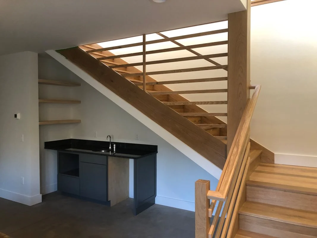 Custom floating staircase with wood railing and integrated landing workspace