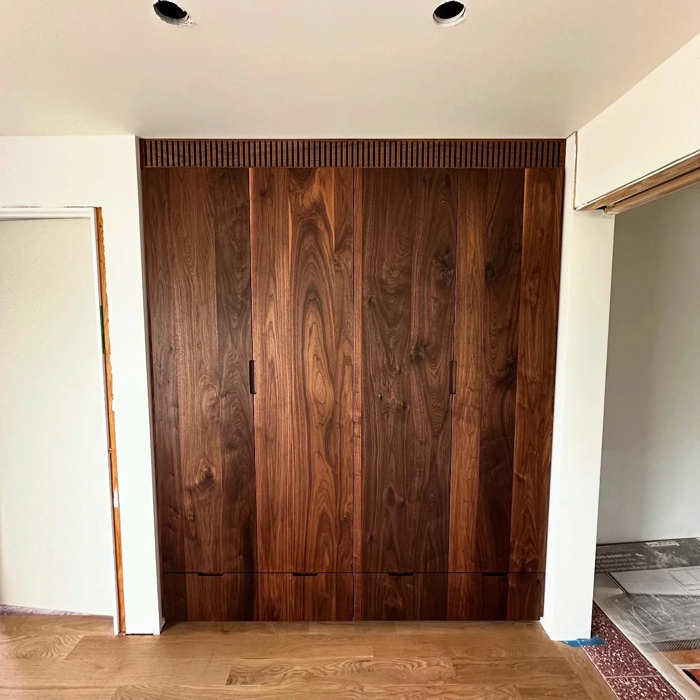 Custom black walnut wardrobe with full-height doors and natural oil finish