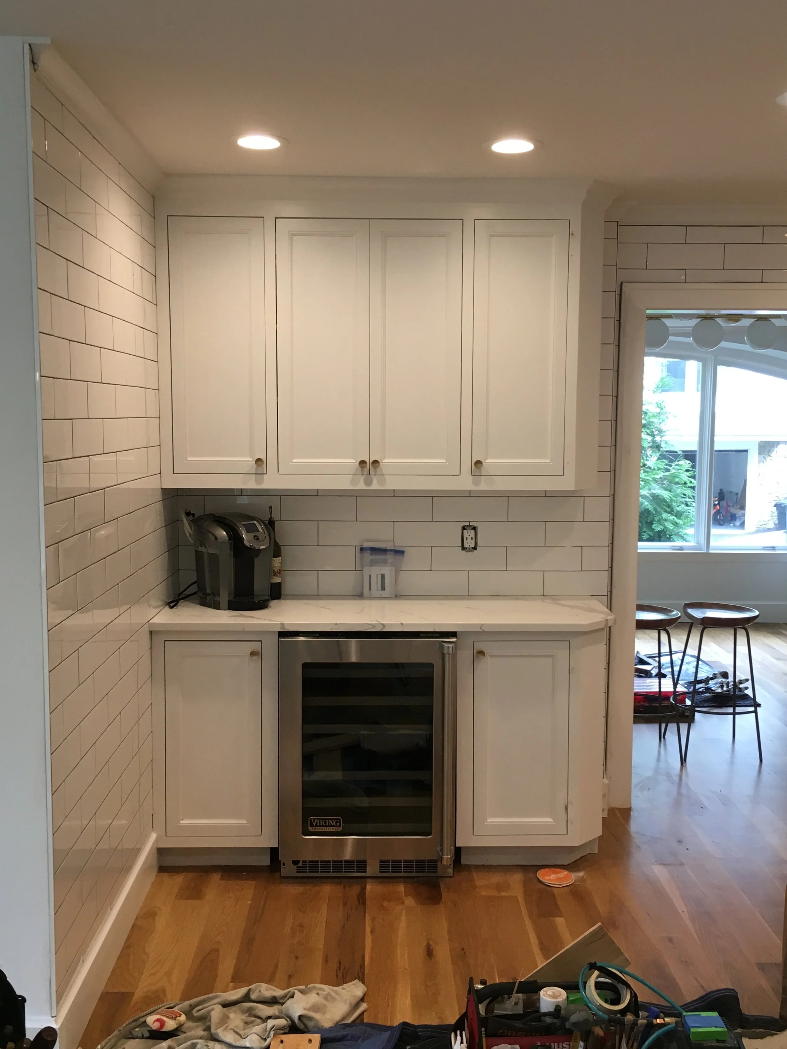 Custom kitchen cabinetry with built-in appliances and tiled wall