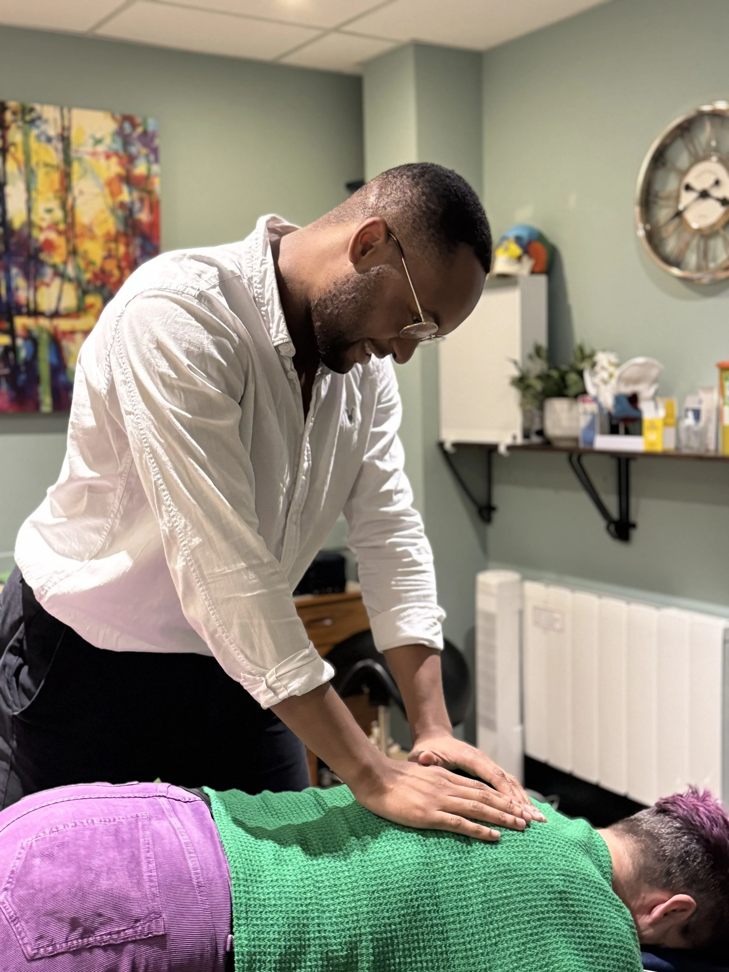 Smiling male clinician treating a patient