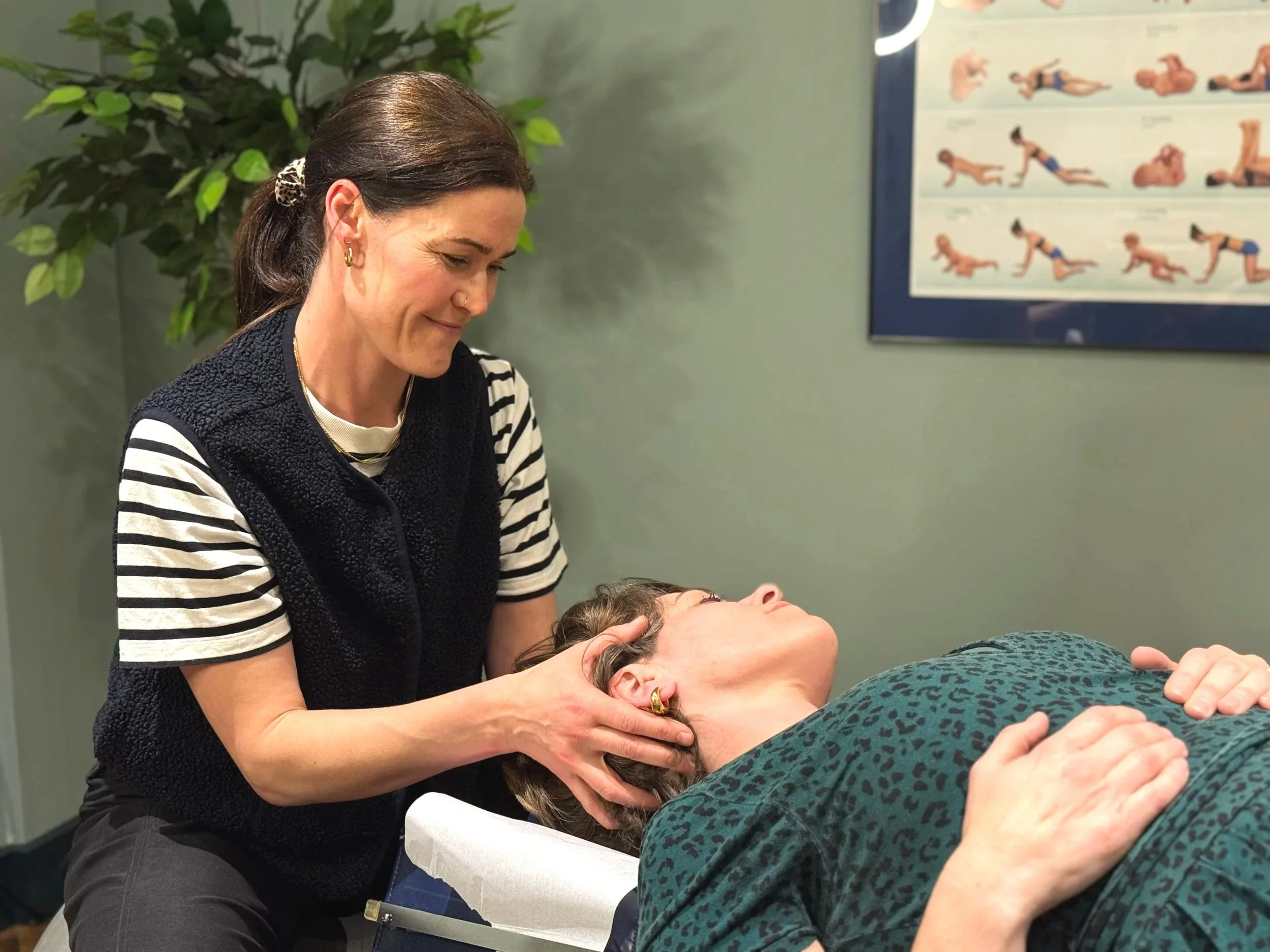 Smiling female chiropractor treating a patient