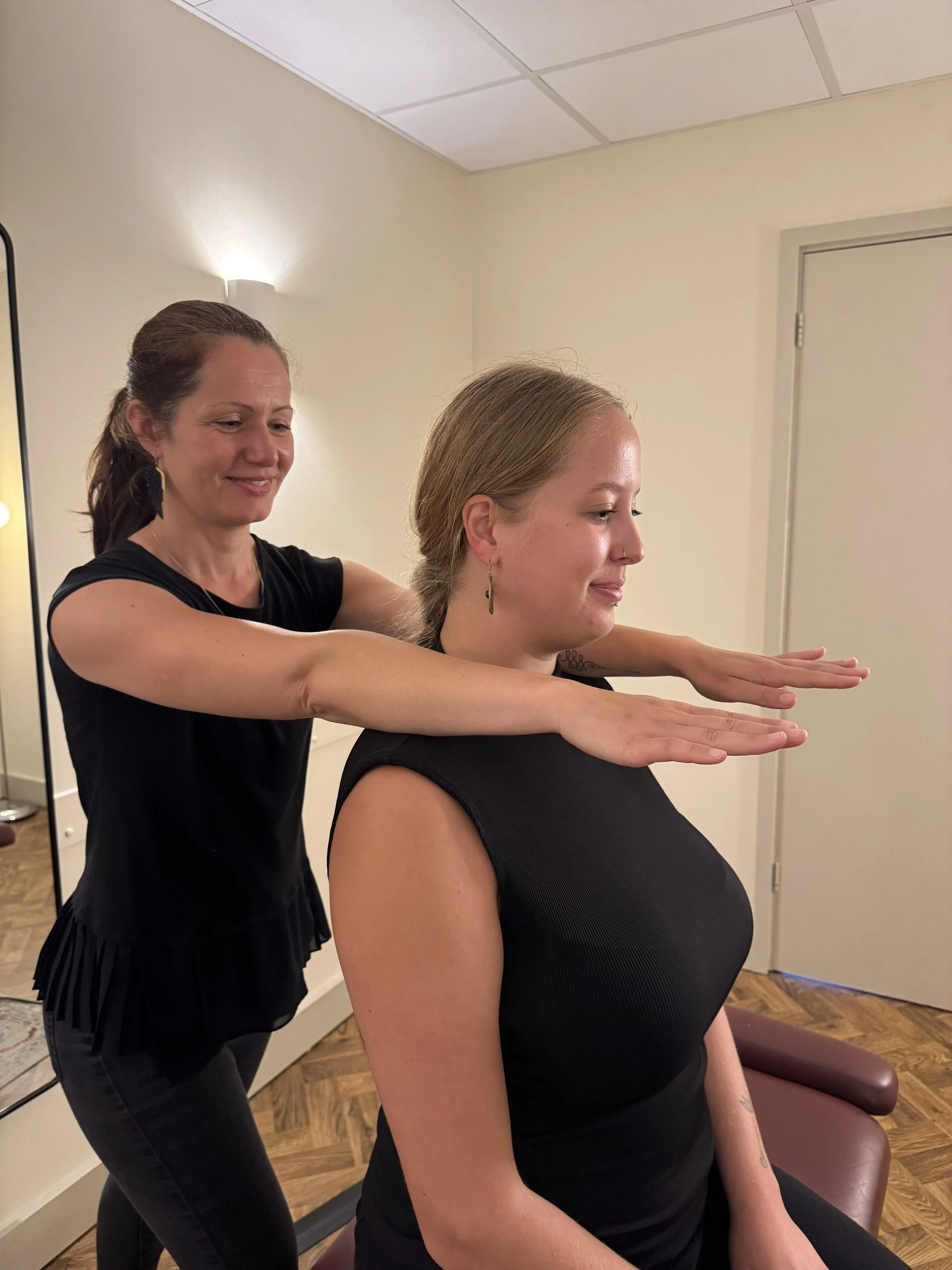 A chiropractor is aligning the shoulder level of a client