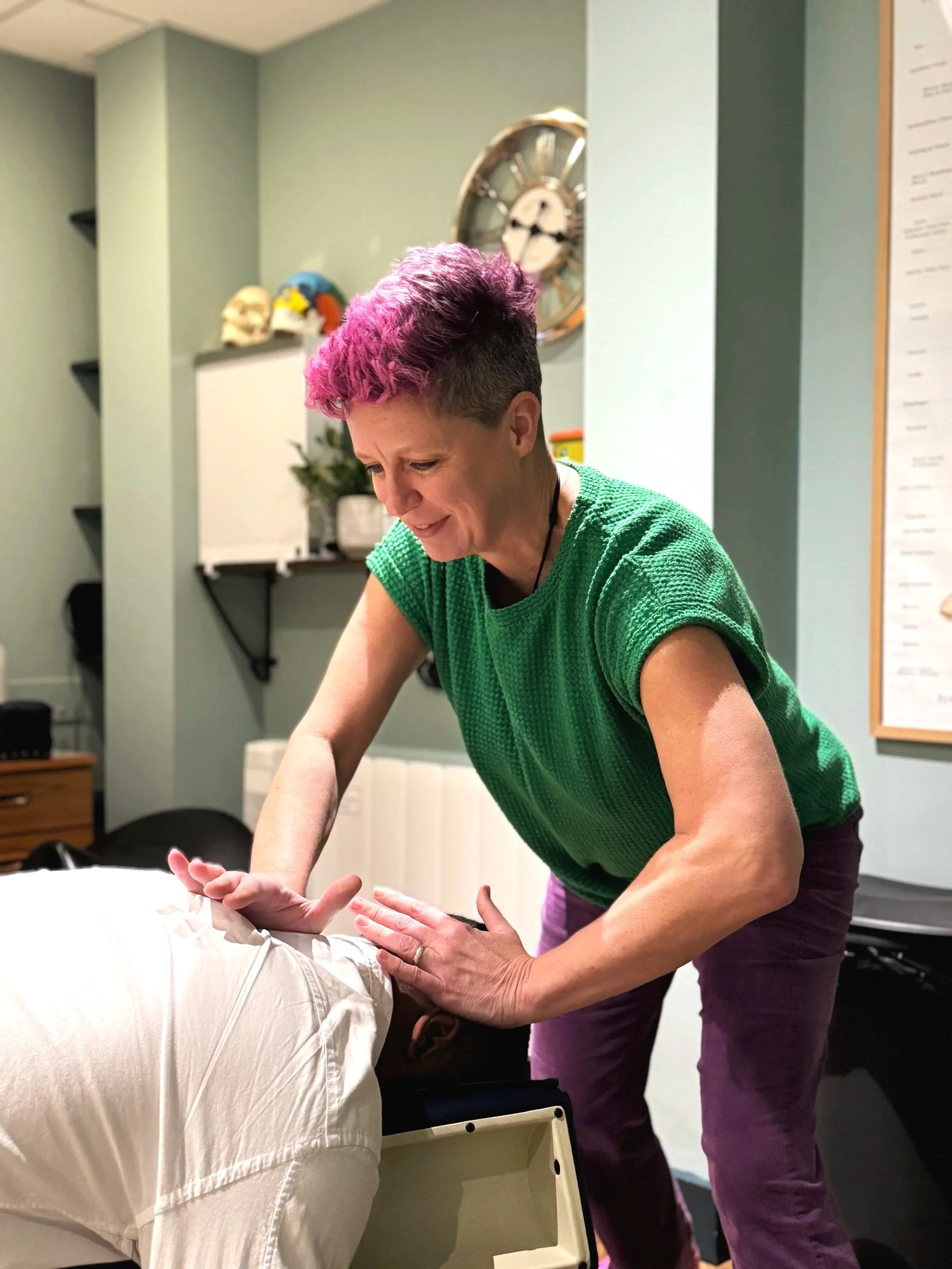 Smiling female chiropractor treating a patient