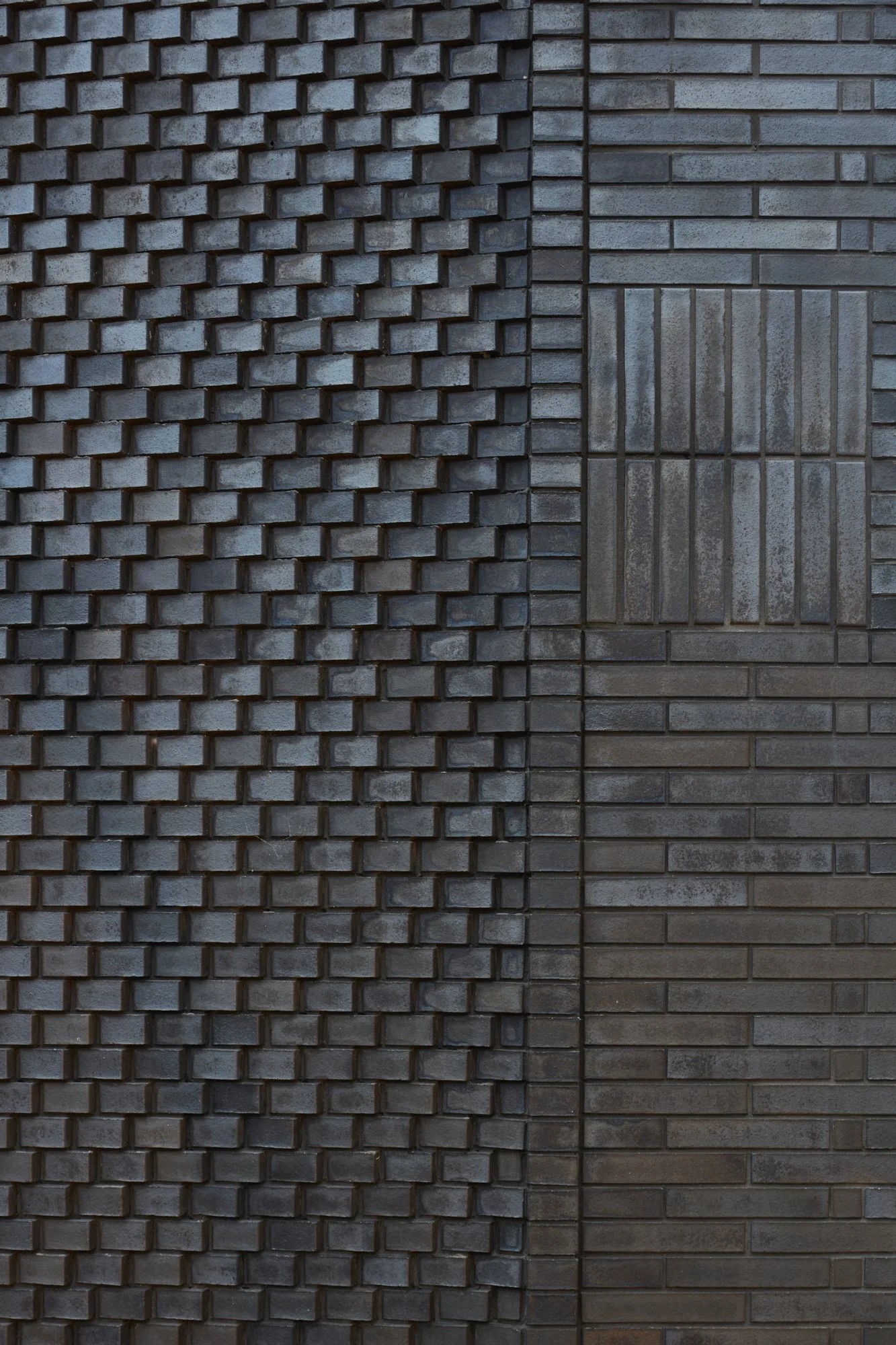 Close-up of a textured brick wall with two distinct patterns. The left side features a 3D cube pattern, while the right side has a standard horizontal brick pattern with a square inset.