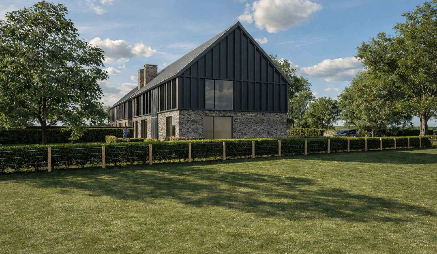 Modern two-story house with stone and black siding exterior, large front yard, and surrounding trees, under a partly cloudy sky.