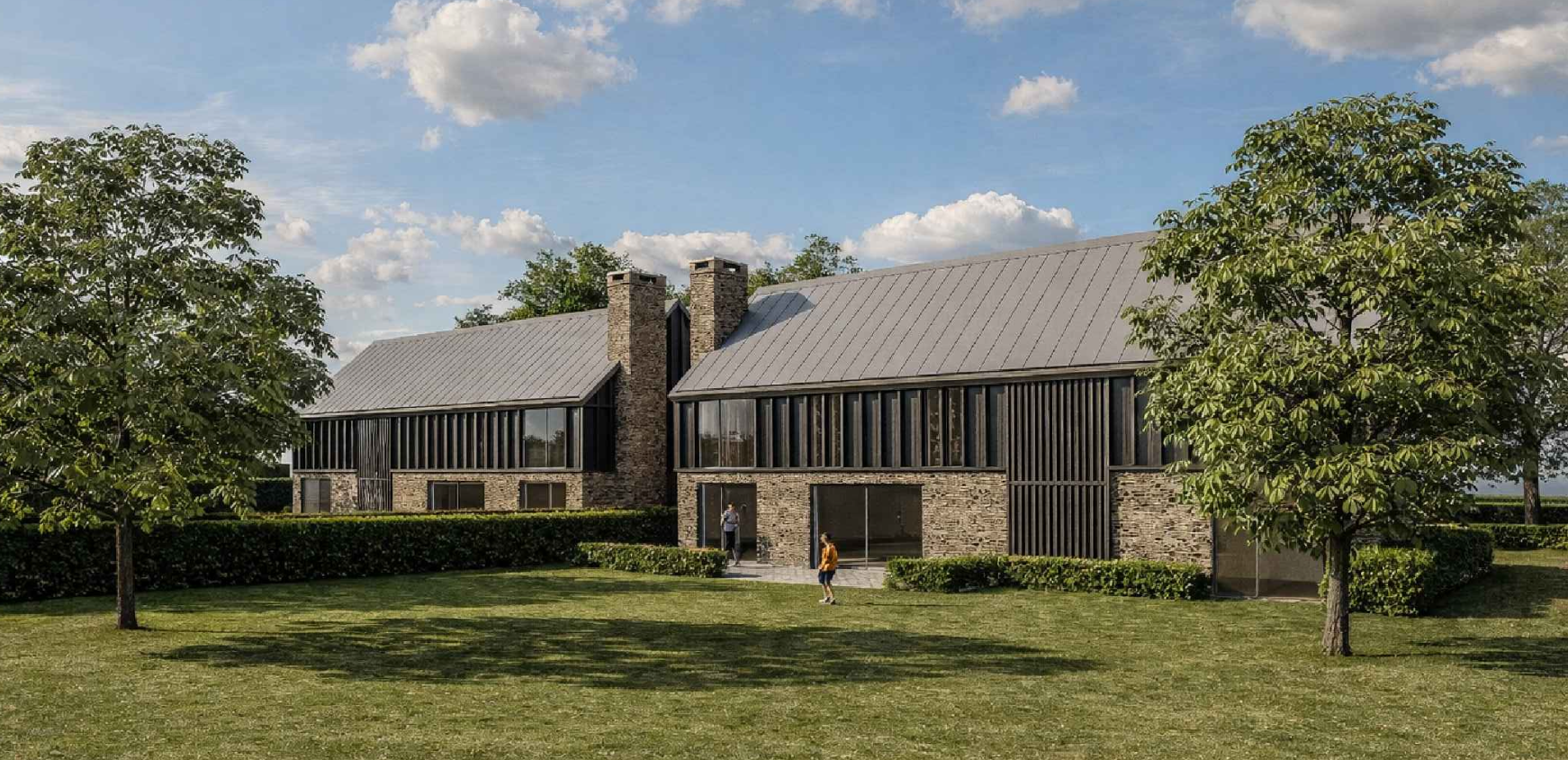 Modern house with brick and wood siding, large windows, and metal roof, surrounded by green lawn and trees, under a partly cloudy sky.