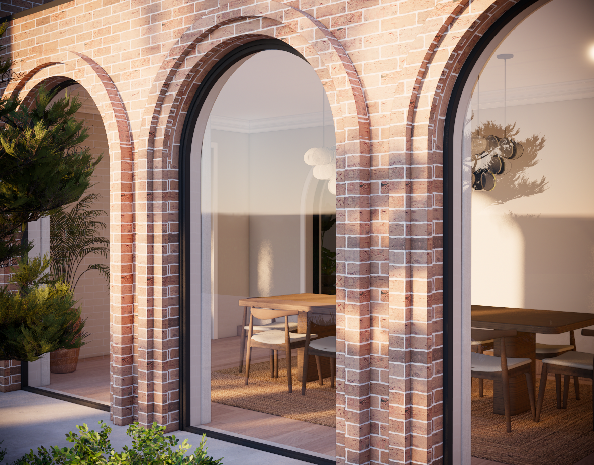 The image shows a brick house with large arched glass windows and sliding glass doors. Inside, there's a dining area with a wooden table, chairs, and houseplants, illuminated by soft lighting.