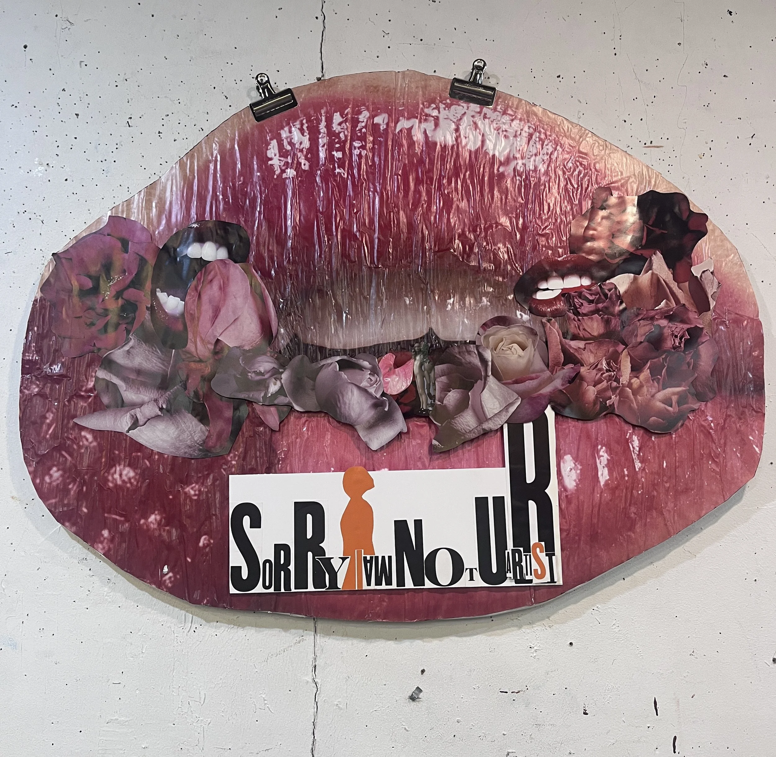 Pink poster on white wall with torn edges and clips at the top, featuring cut-out letters and images of lips and flowers, with some visible text.