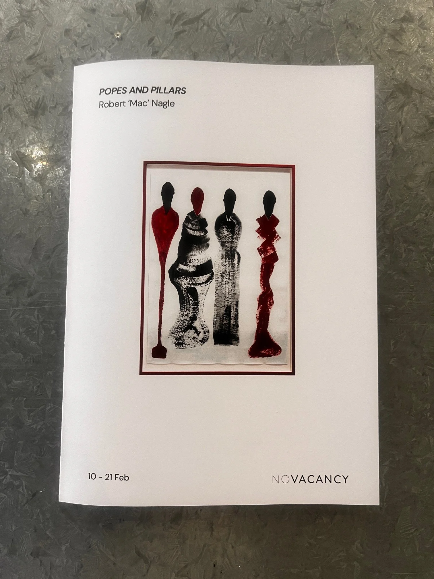 A  or poster for an art exhibition titled 'Popes and Pillars' by Robert 'Mac' Nagle, held from February 10th to 21st. The artwork features three stylized female figures with elongated bodies in black and red, depicted in a minimalistic and abstract style, enclosed in a rectangular border.