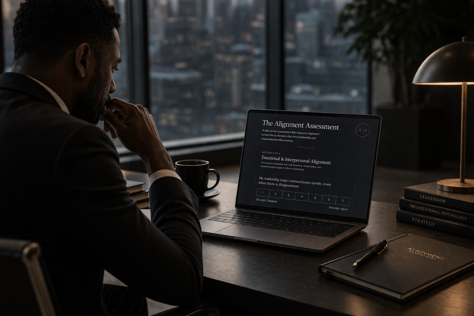 Man in business attire sitting at desk, looking at a laptop screen displaying an assessment form titled 'The Alignment Assessment' in a modern office with city view through windows.