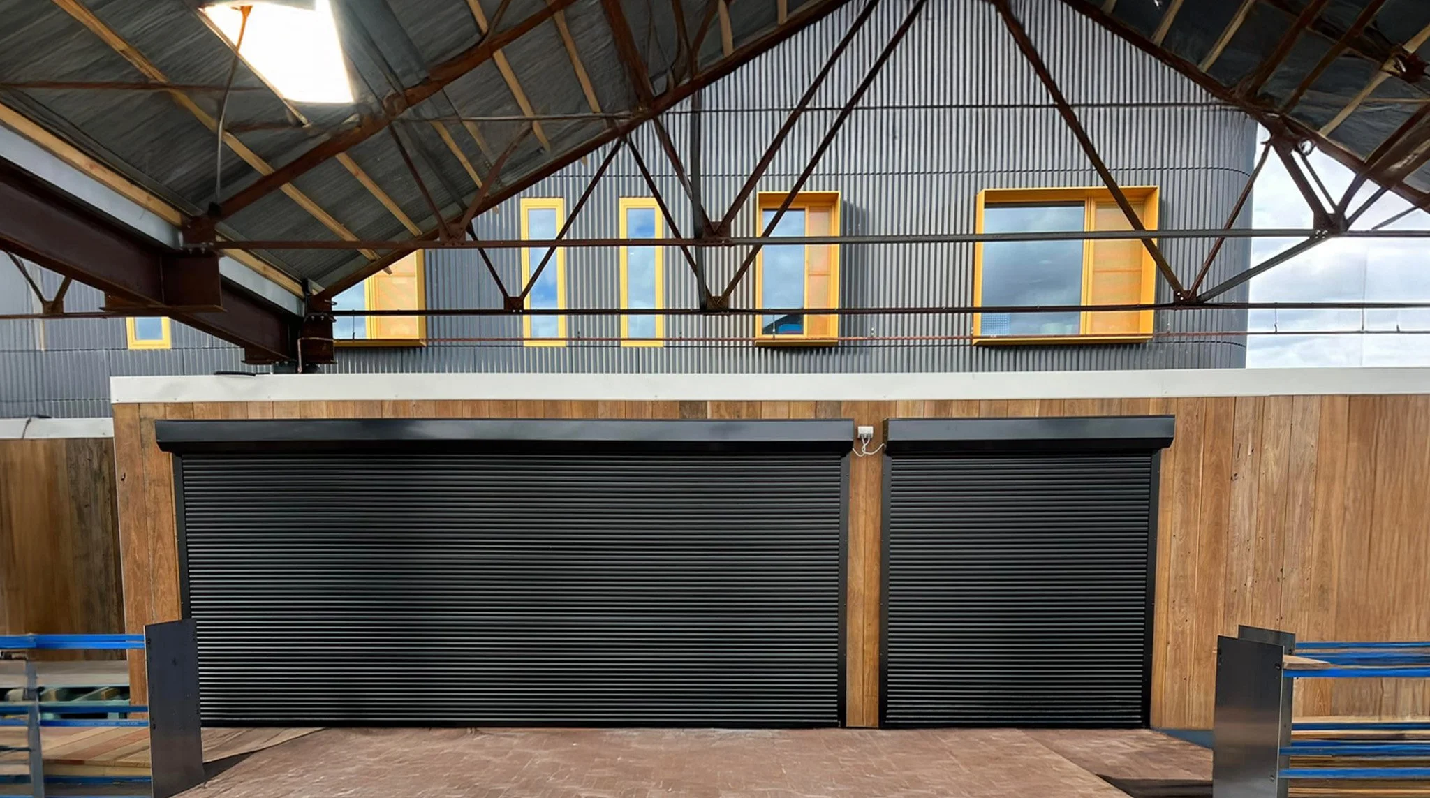 Two black roll-up roller shutter doors, on a modern building in Sydney, NSW.