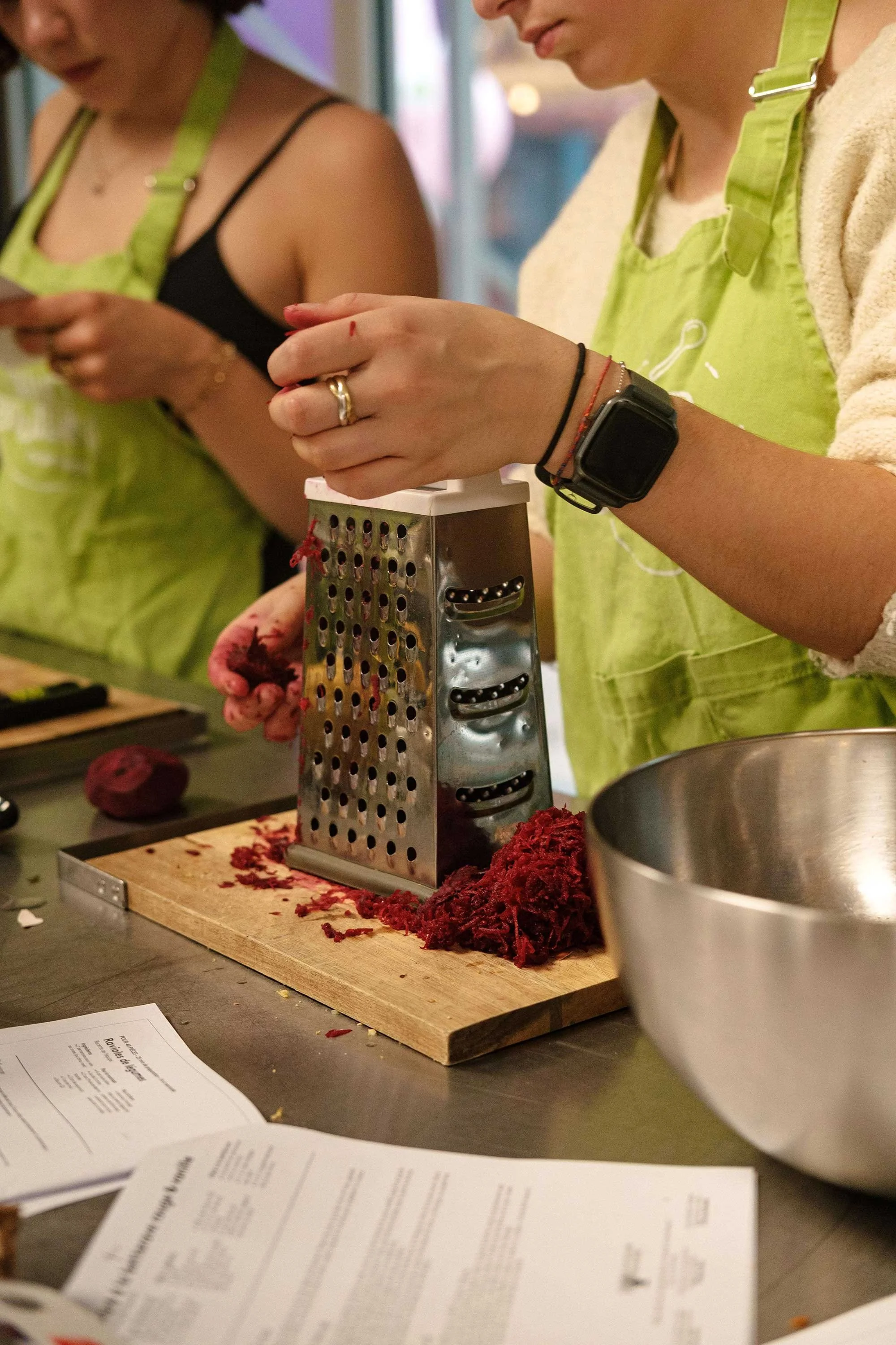 Participantes râpant des betteraves rouges lors d'un atelier de cuisine durable organisé par la Communauté Écotable à Lille.