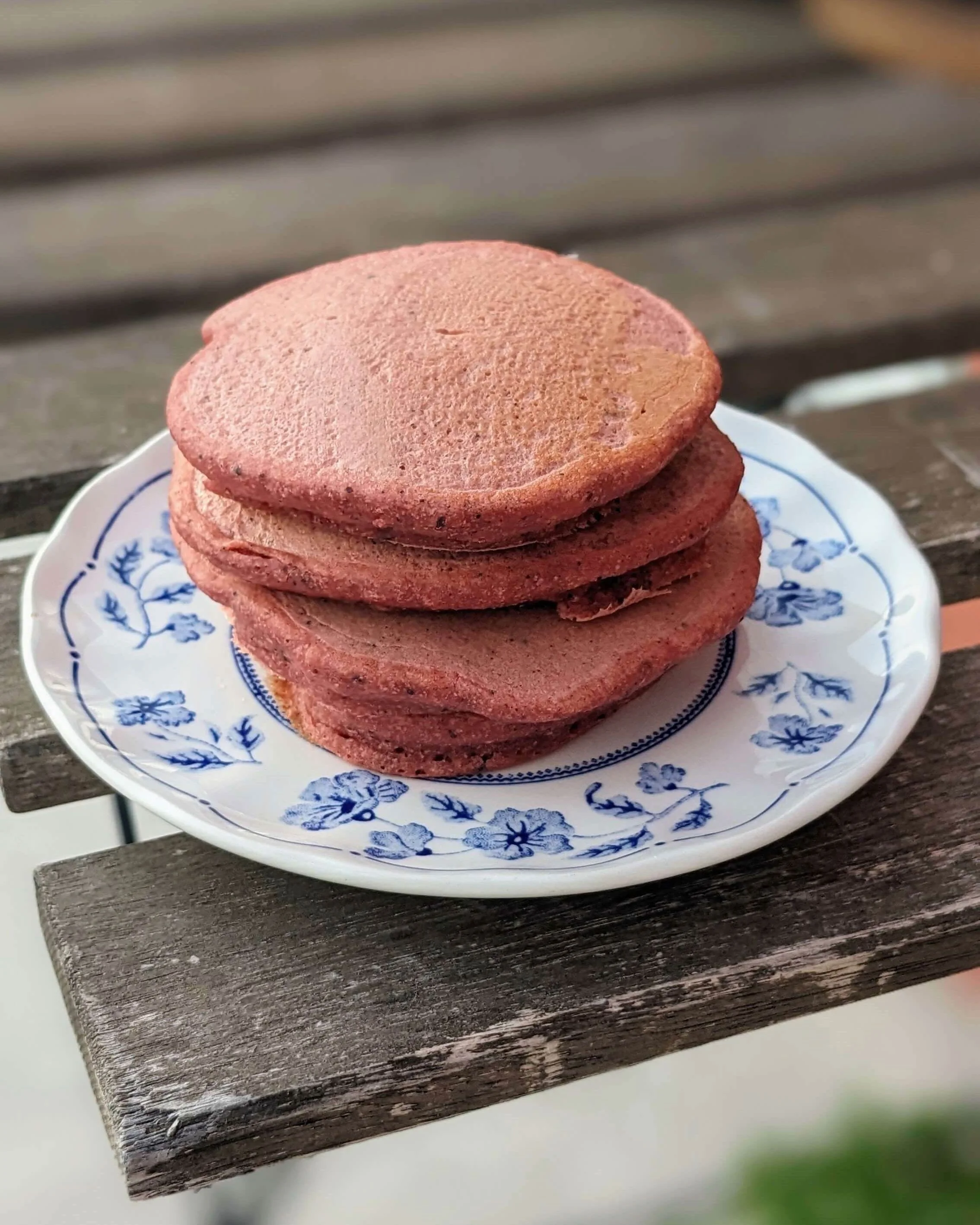 Pile de blinis à la betterave rouge disposée sur une table en bois, une alternative locale et colorée pour l'apéritif.