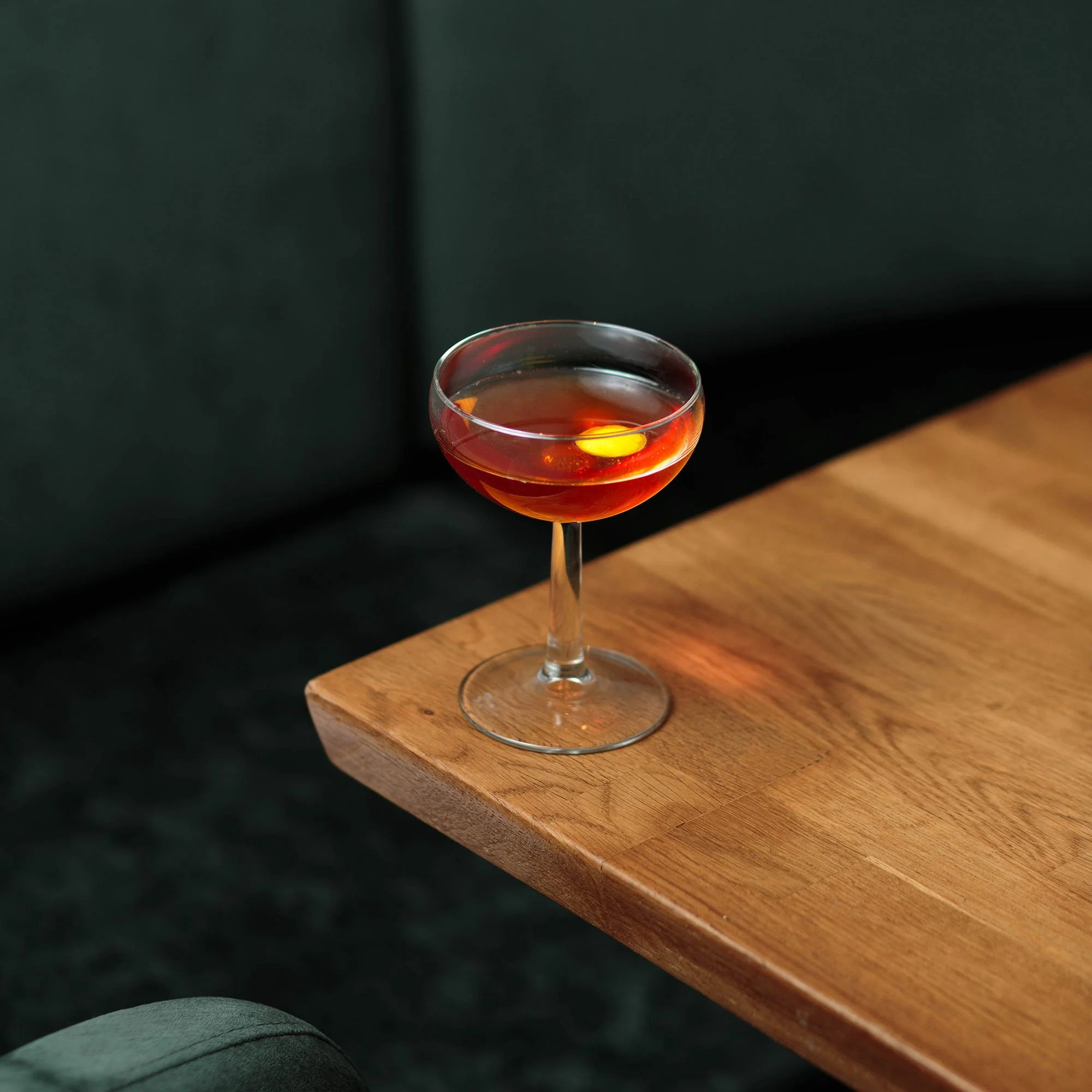 Mise en scène élégante d'un cocktail Amérisse sur une table en bois.