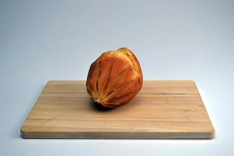 Brioche démoulée posée sur une planche en bois, révélant les marques du pliage.