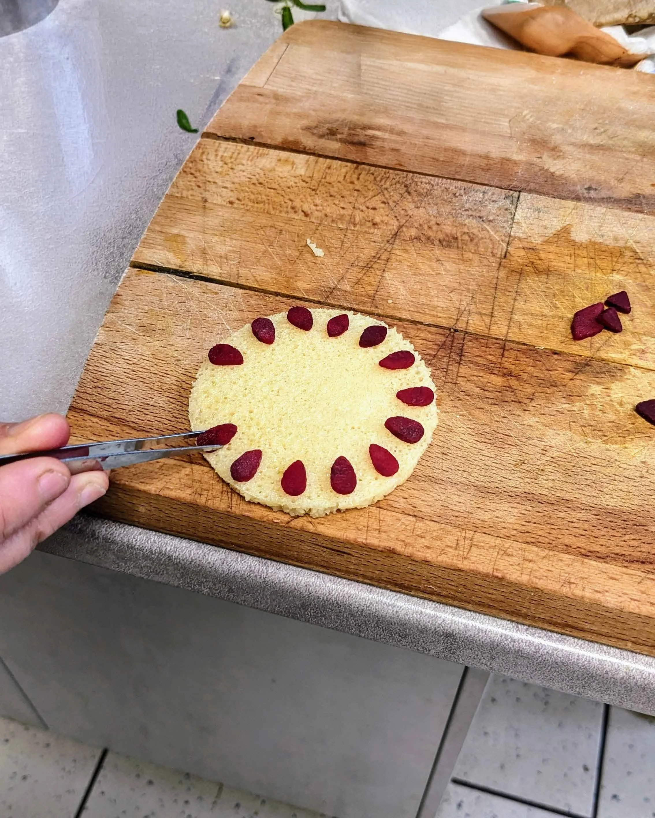 Utilisation d'une pince de précision pour composer un motif délicat sur une crêpe traditionnelle.
