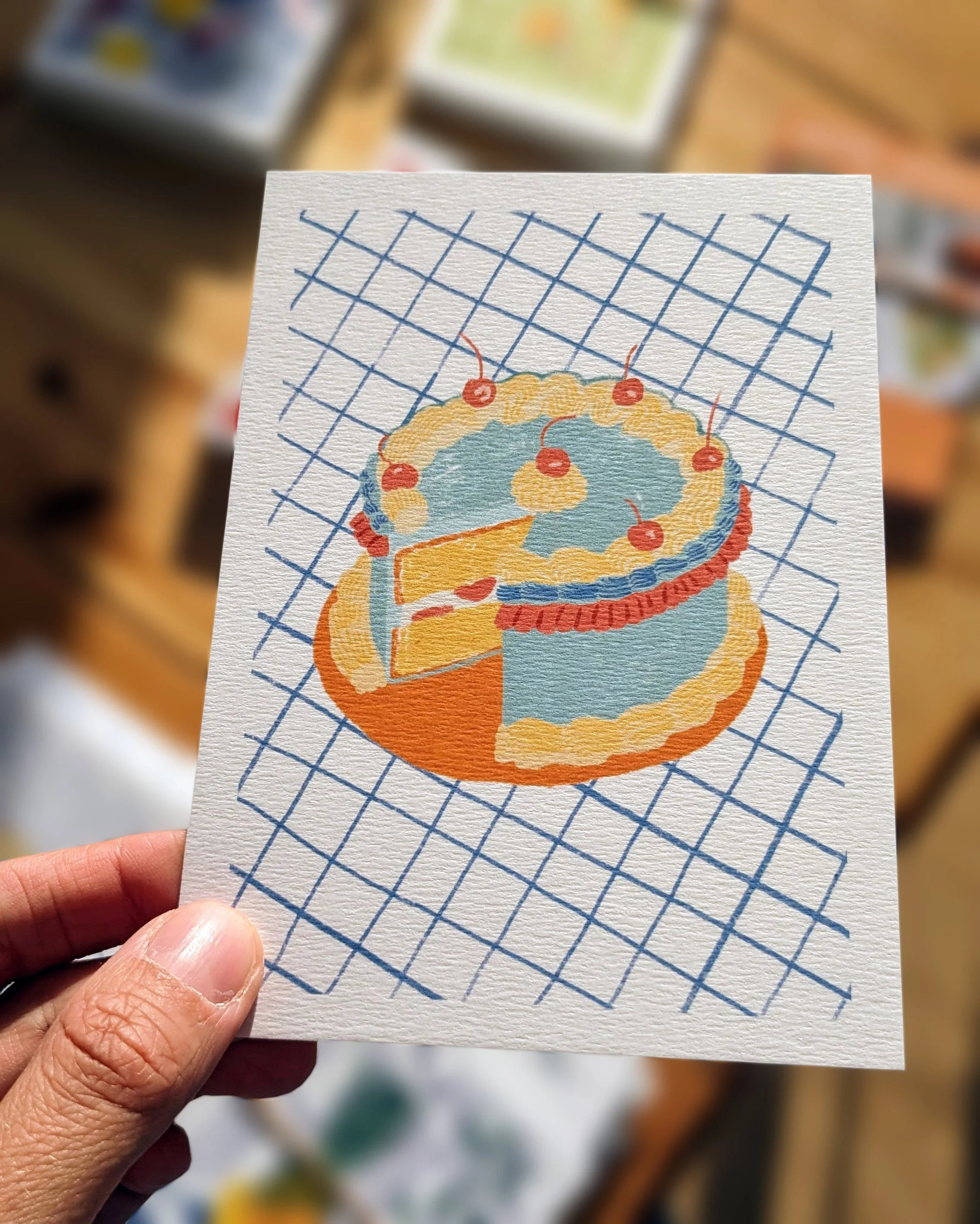 Carte postale illustrée d'anniversaire représentant un gâteau au style vintage, sur fond à carreaux