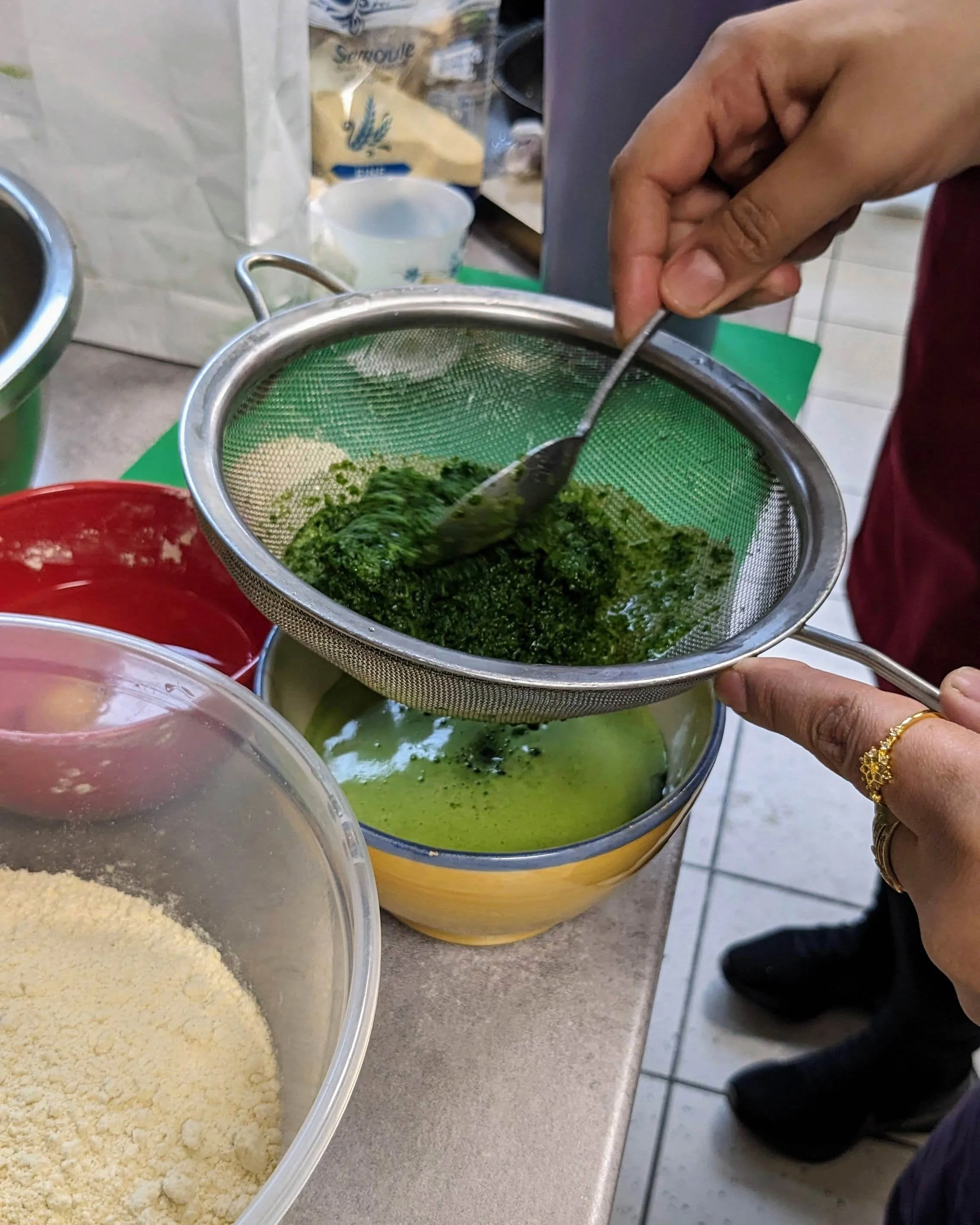 Extraction manuelle de jus d'épinard pour créer un colorant alimentaire vert naturel durant l'atelier.