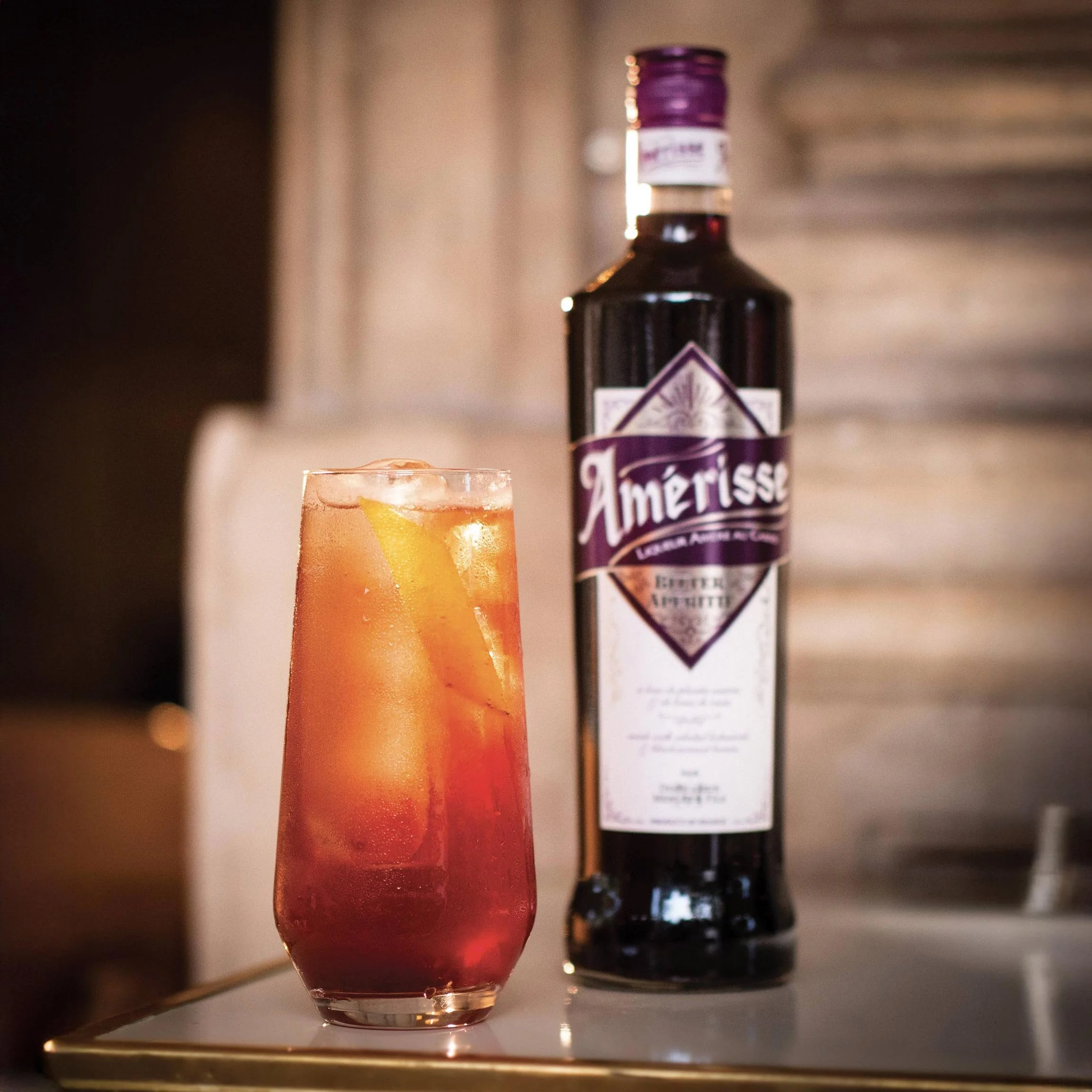 Gros plan sur la robe rouge intense du bitter Amérisse avec sa bouteille emblématique.