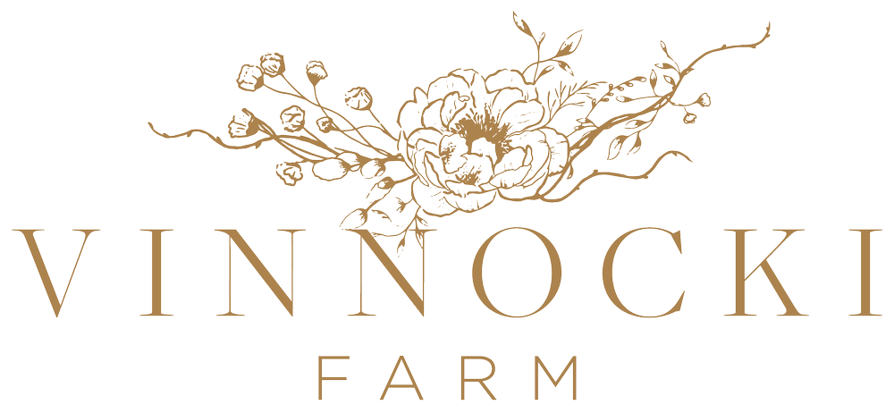 Logo of Vinnocki Farm with a lion's head surrounded by floral and vine illustrations.