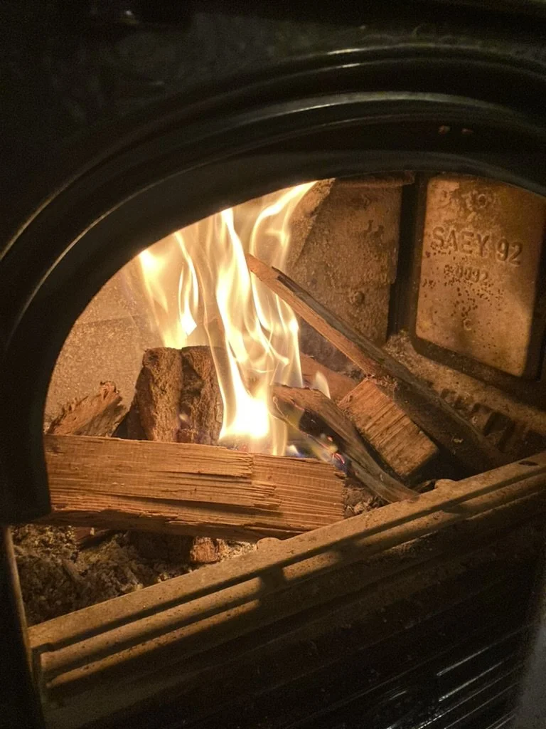Vlammen in een houtkachel met brandend hout dat in het vuur ligt.