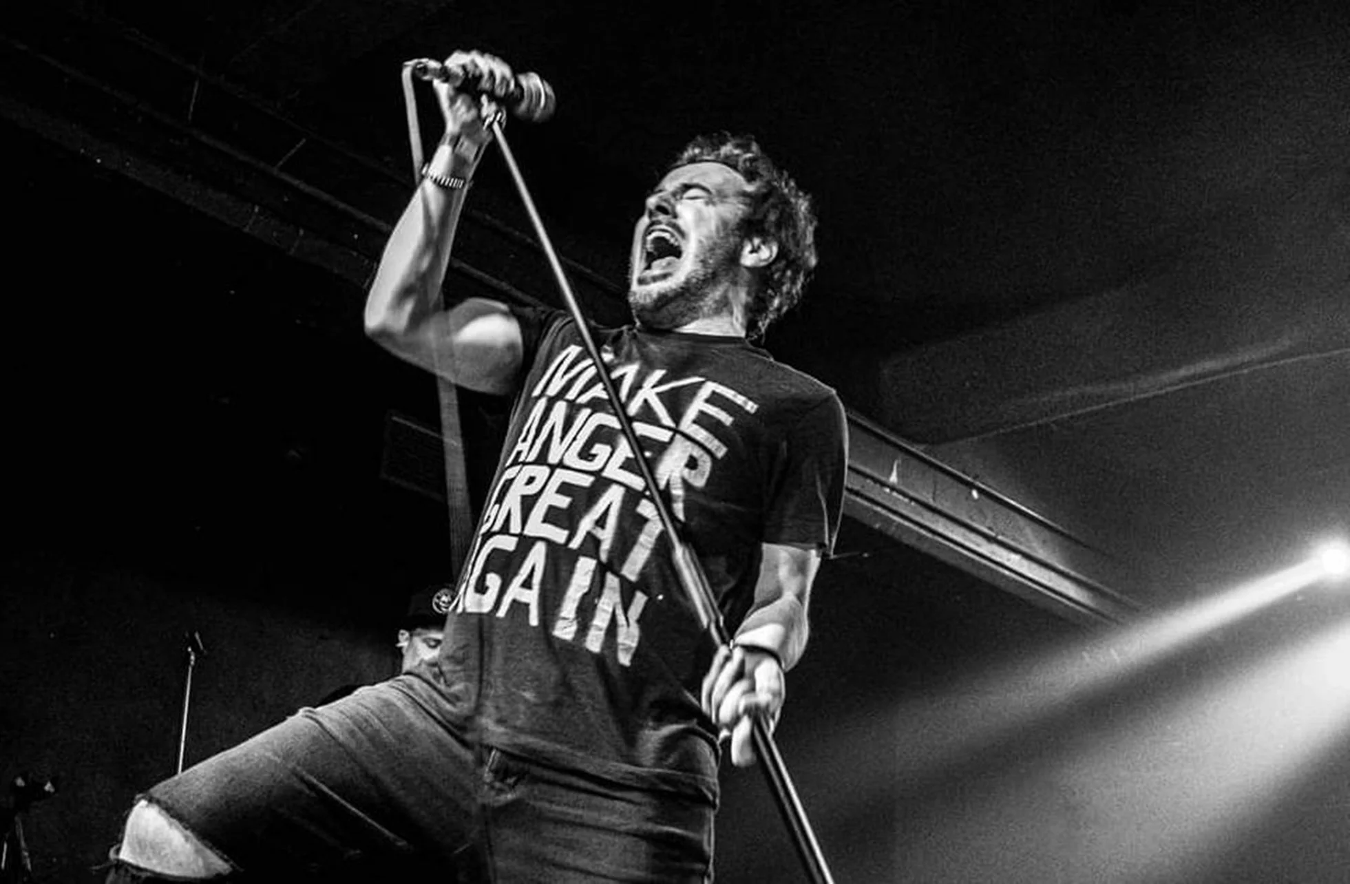 James Kennedy, the singer, author and podcaster from Wales screaming into a microphone during a concert with his band 'James Kennedy and The Underdogs'