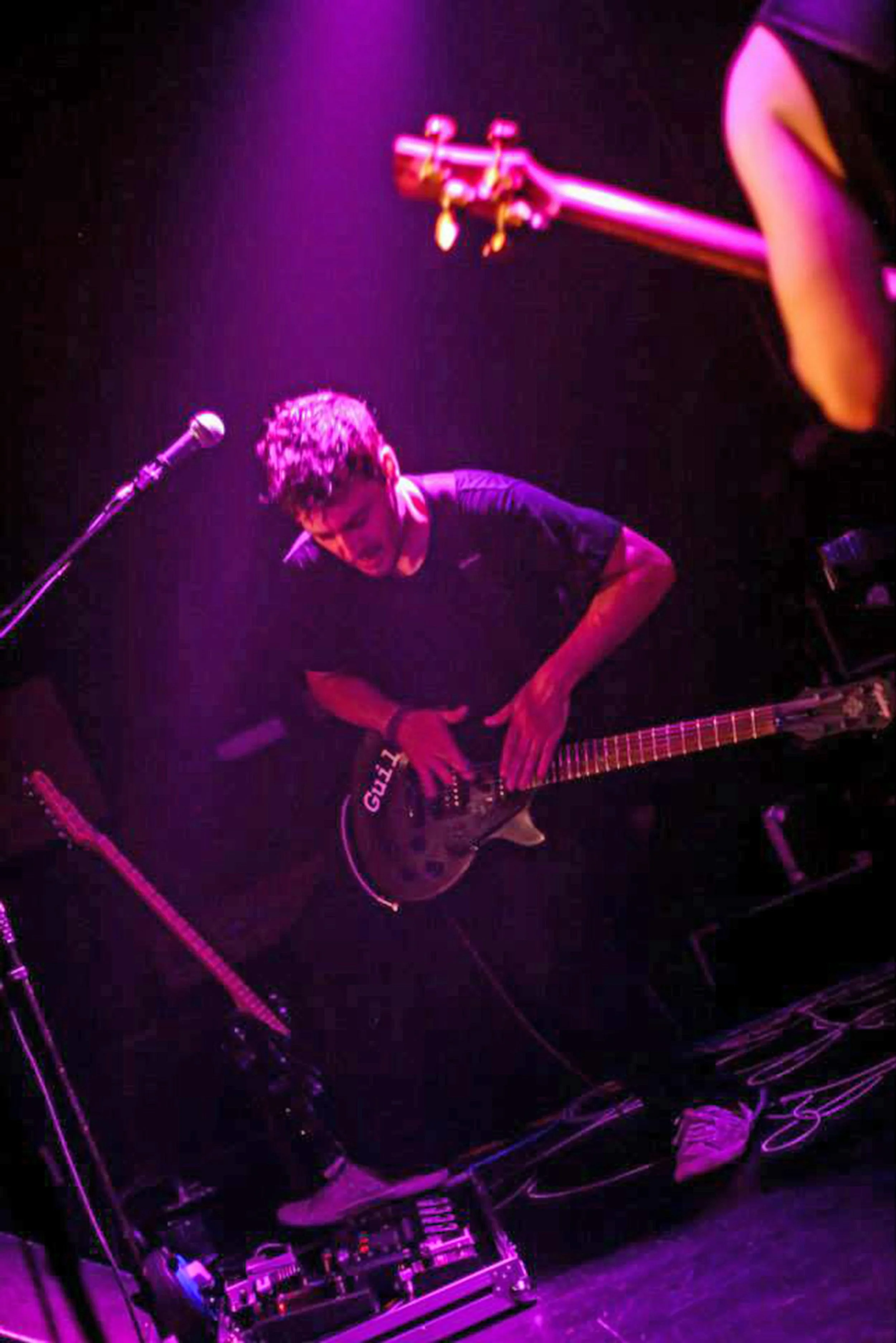 James Kennedy, the singer and musician playing guitar on stage with his band 'Kyshera' at a live concert in London