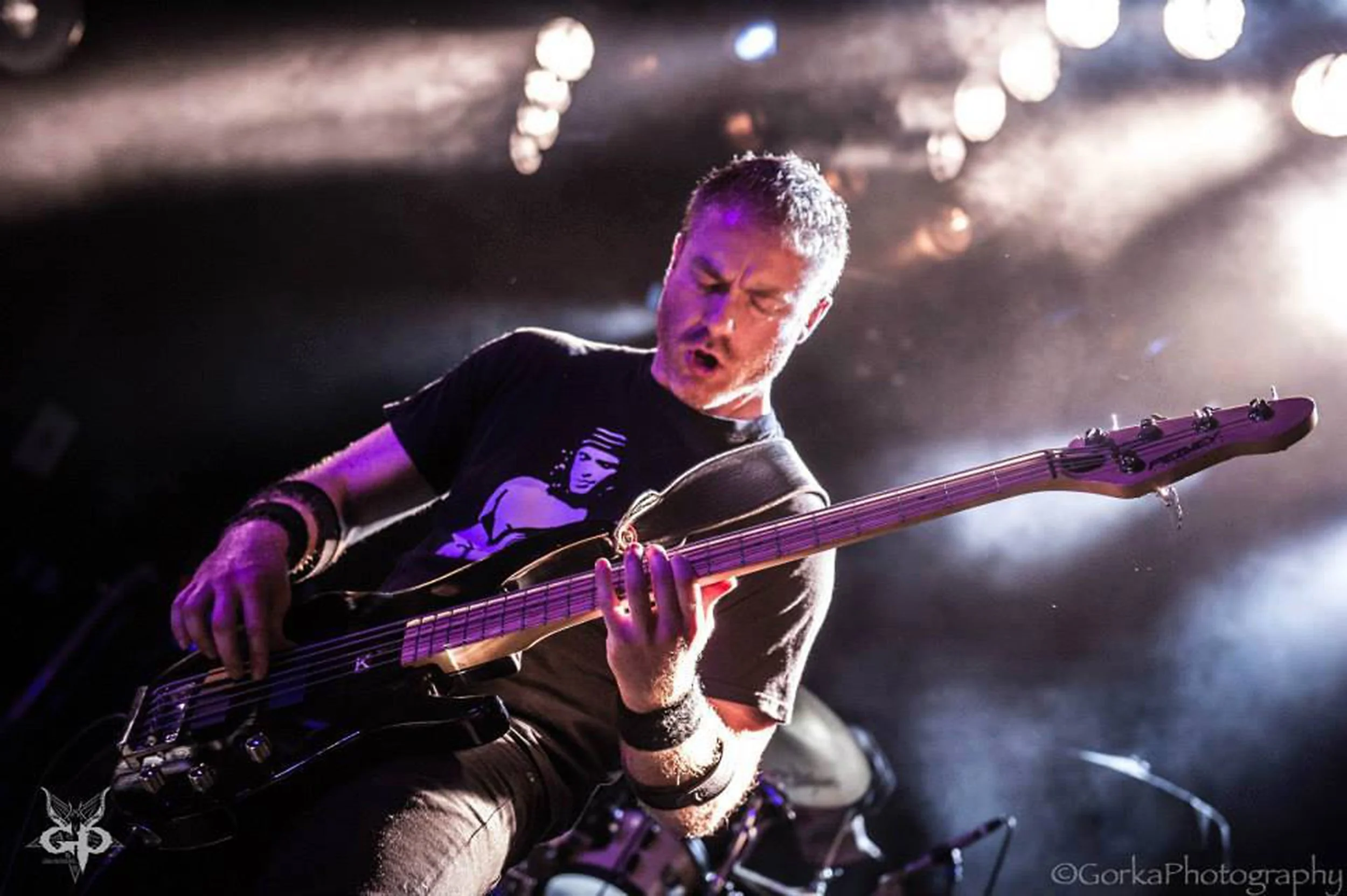 Matt Warr, the bassist in the rock band 'Kyshera' playing bass on stage with cool stage lights on tour in Europe