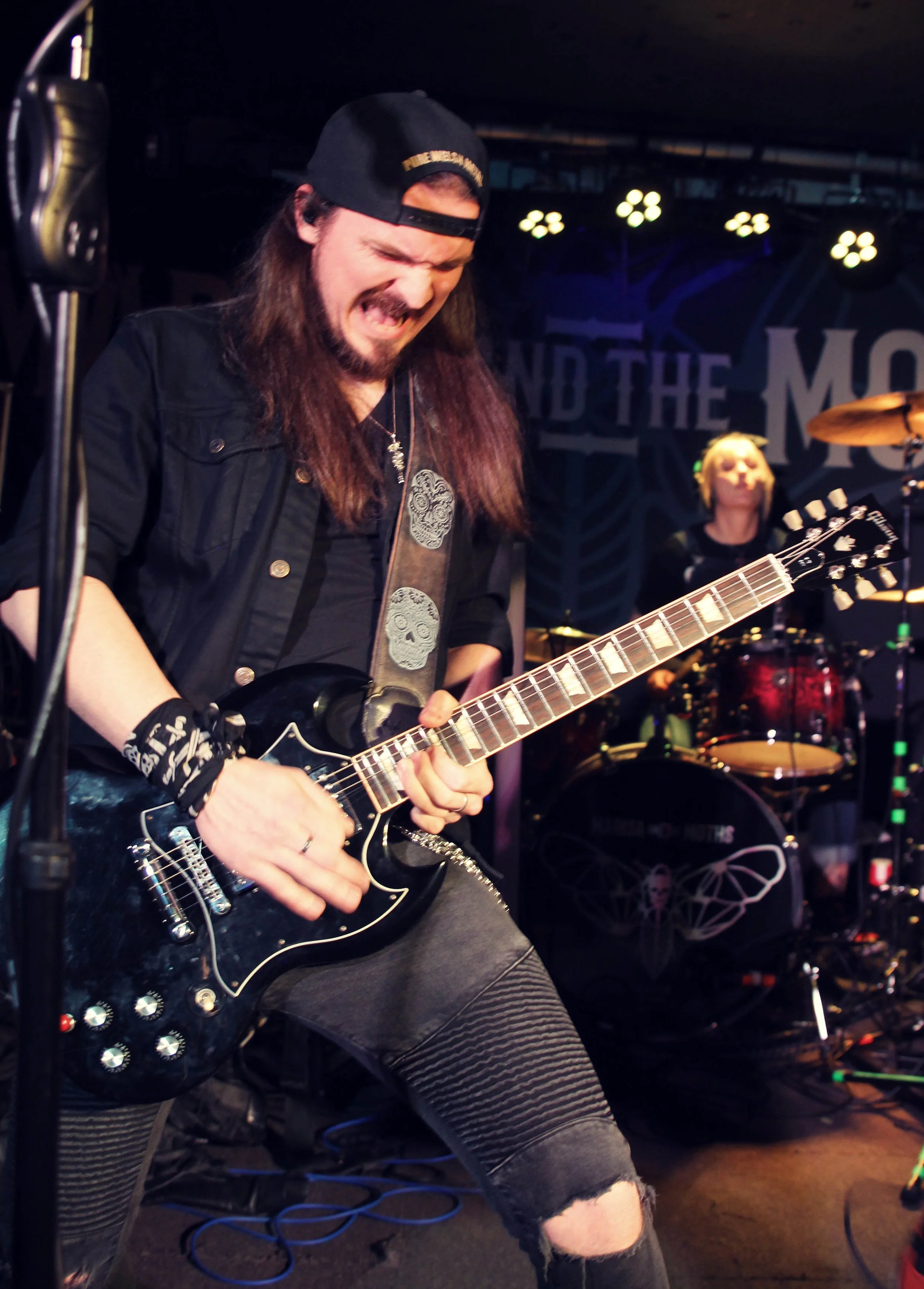 Jack Davies, guitarist with the Welsh punk rock band, 'James Kennedy and The Underdogs' playing a black Gibson SG at a concert and screaming at the guitar 