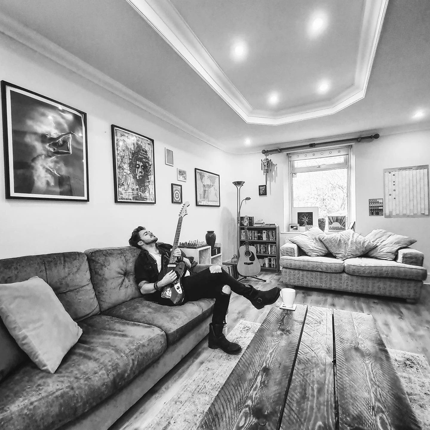 James Kennedy, the singer, author and podcaster from Wales, playing guitar at his home 